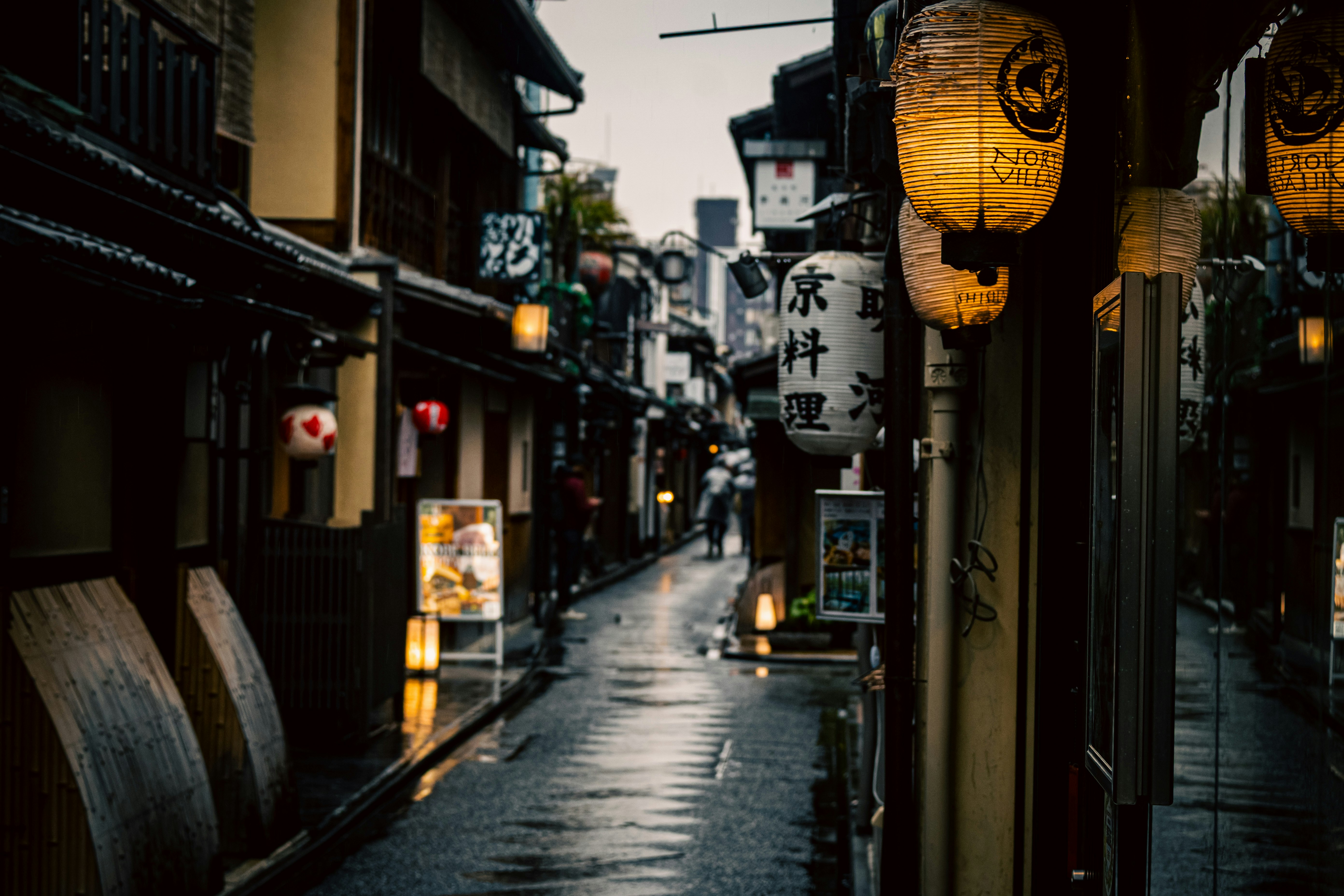提灯が並ぶ狭い路地の商店街の軒先