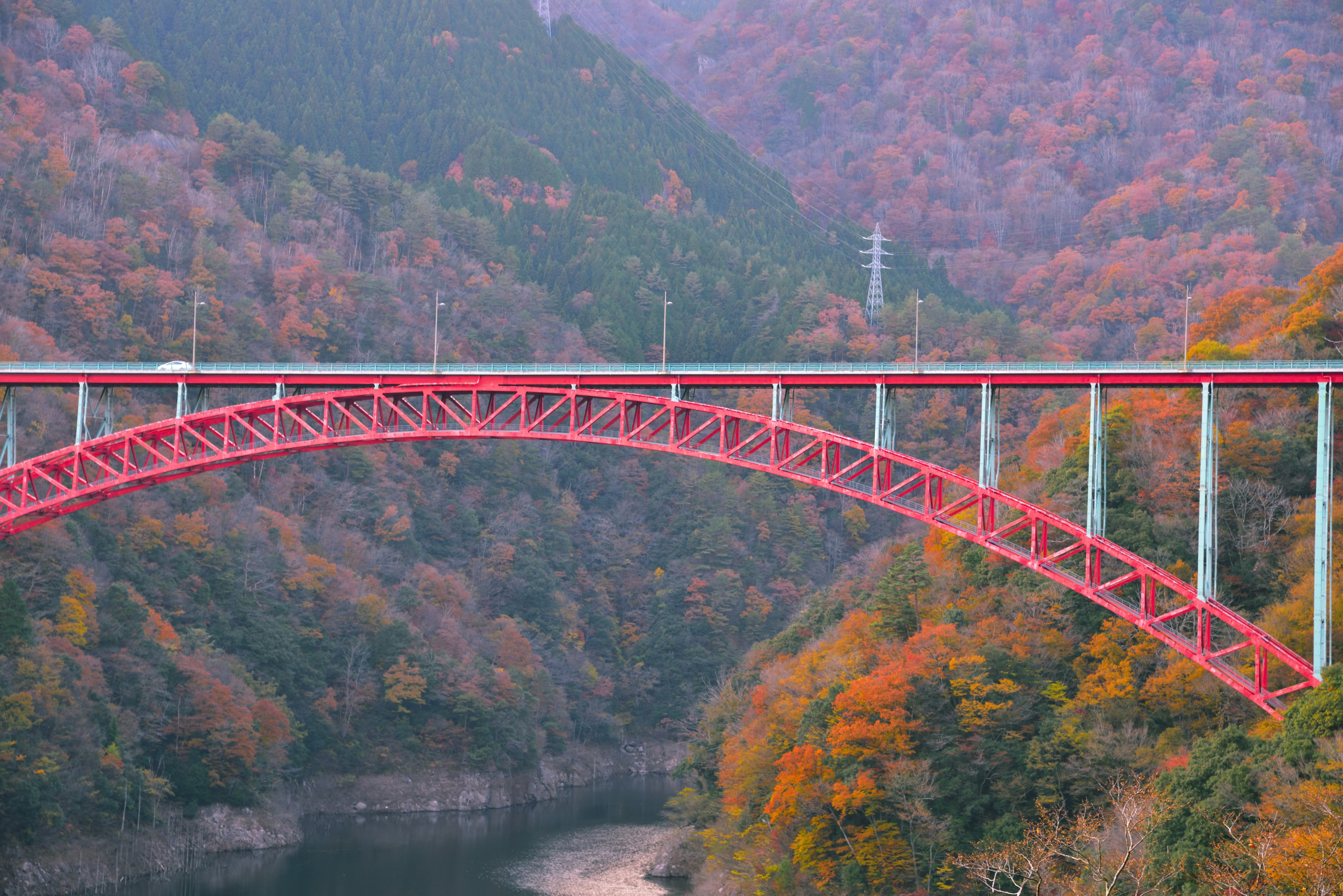 Scenic view of a red railway bridge crossing an autumn valley