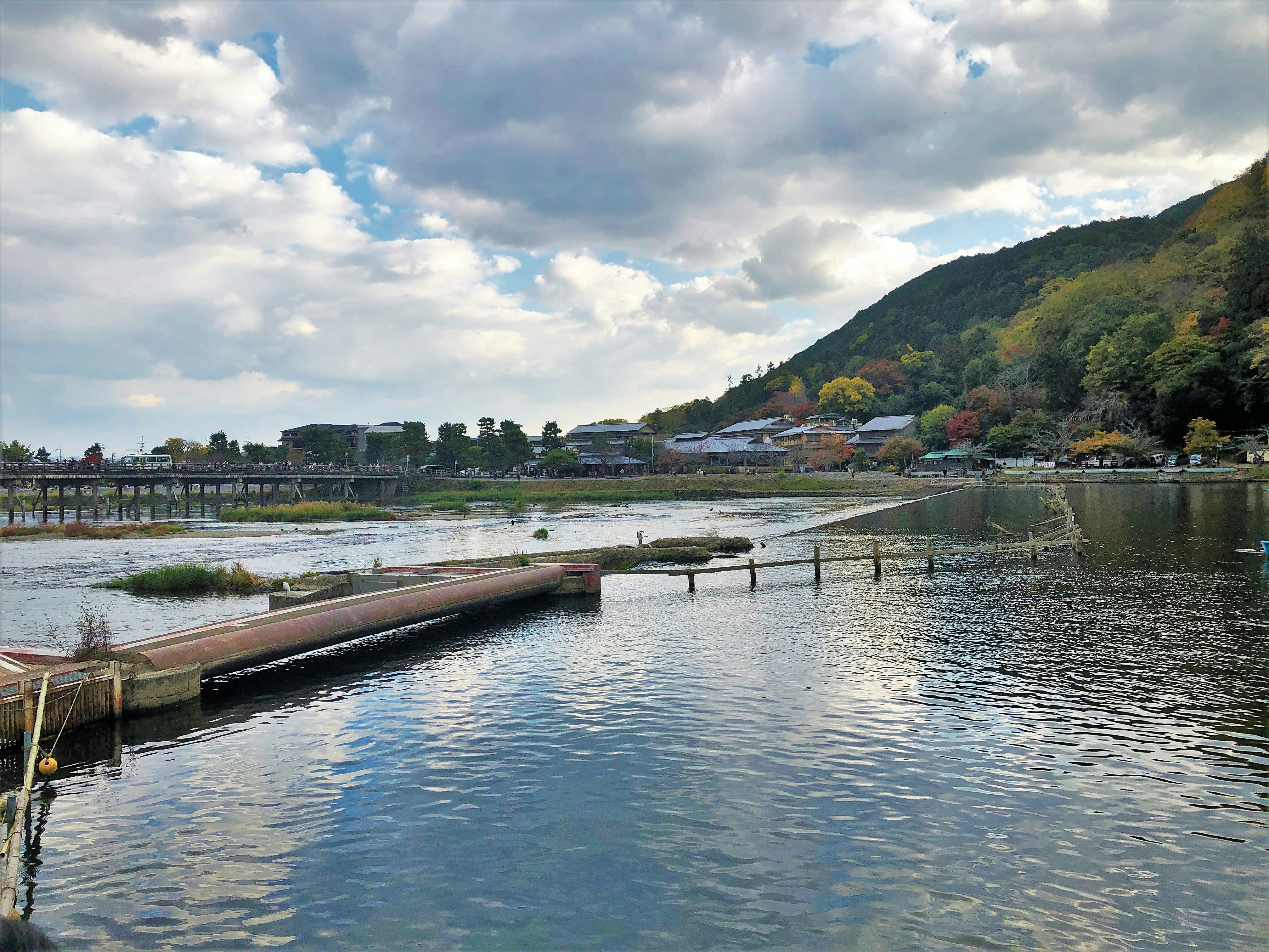 川沿いの桟橋と水面、山並みが望める景色