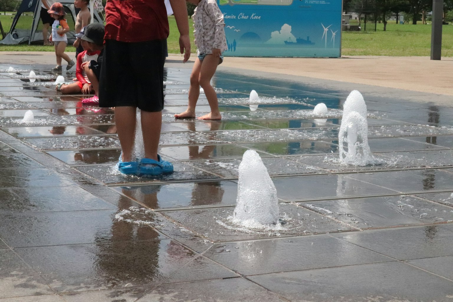 孩子們在公園的噴泉區玩水