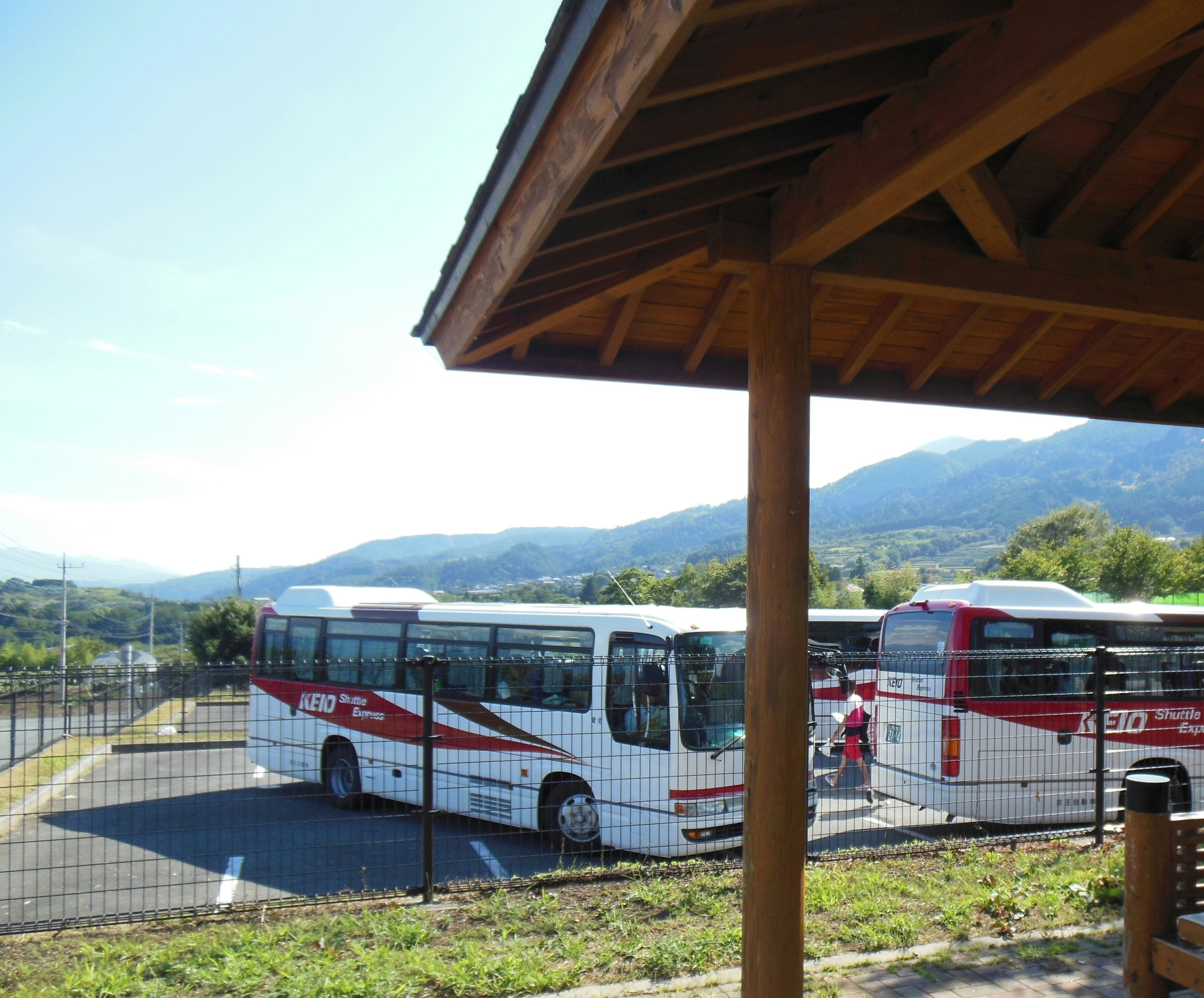 buses parked in front of a covered station shelter