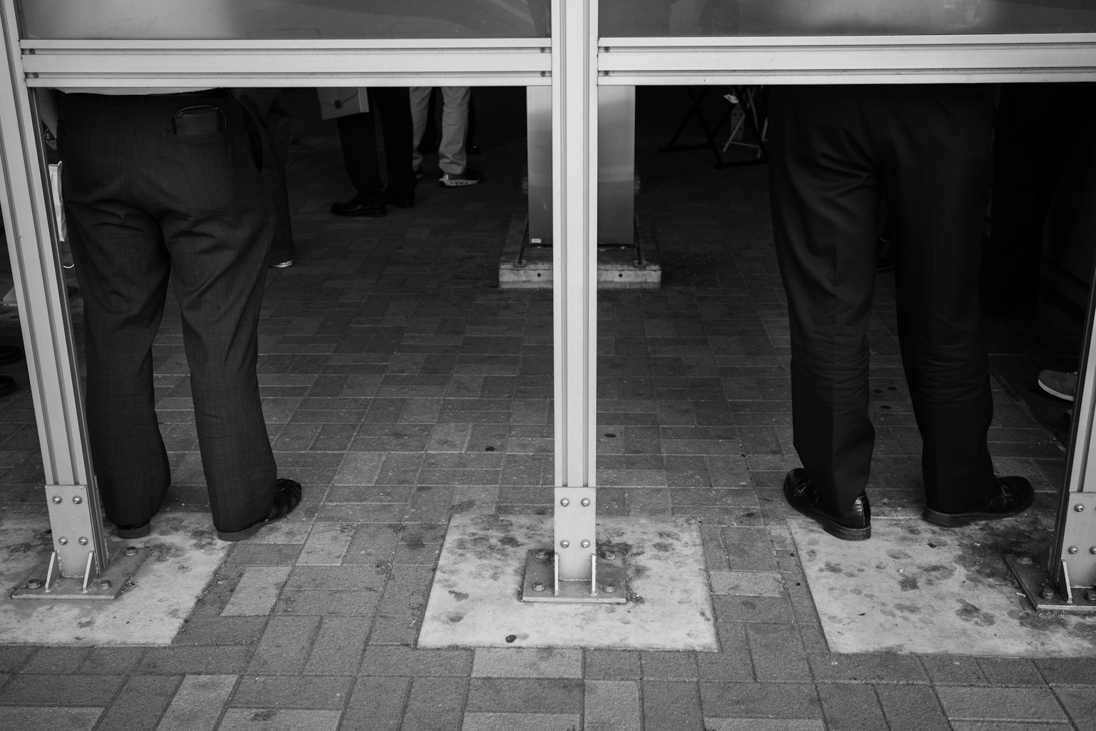 Image en noir et blanc montrant deux hommes en costume se tenant côte à côte