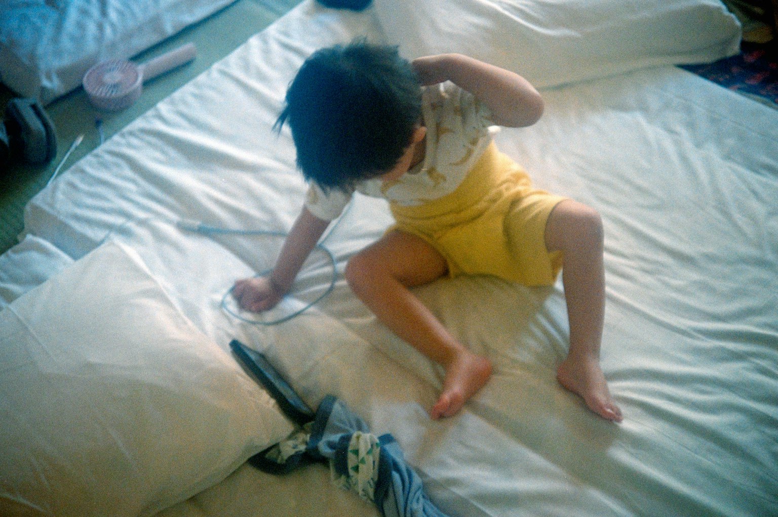 子供がベッドの上で遊んでいる様子 黄色いパンツを履いている