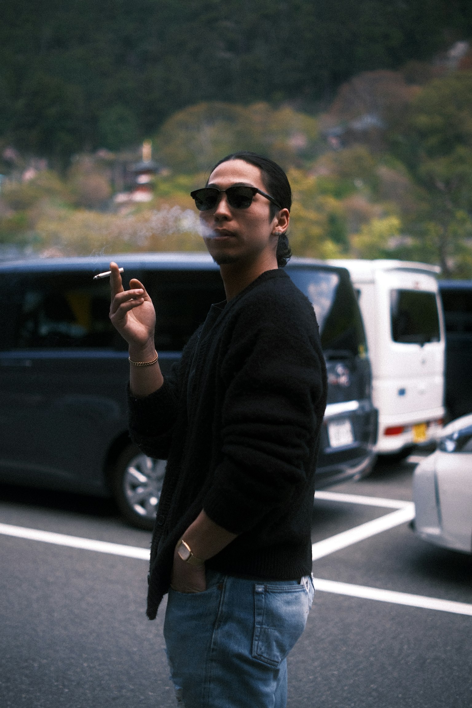 穿黑色毛衣的男人戴著太陽眼鏡抽煙