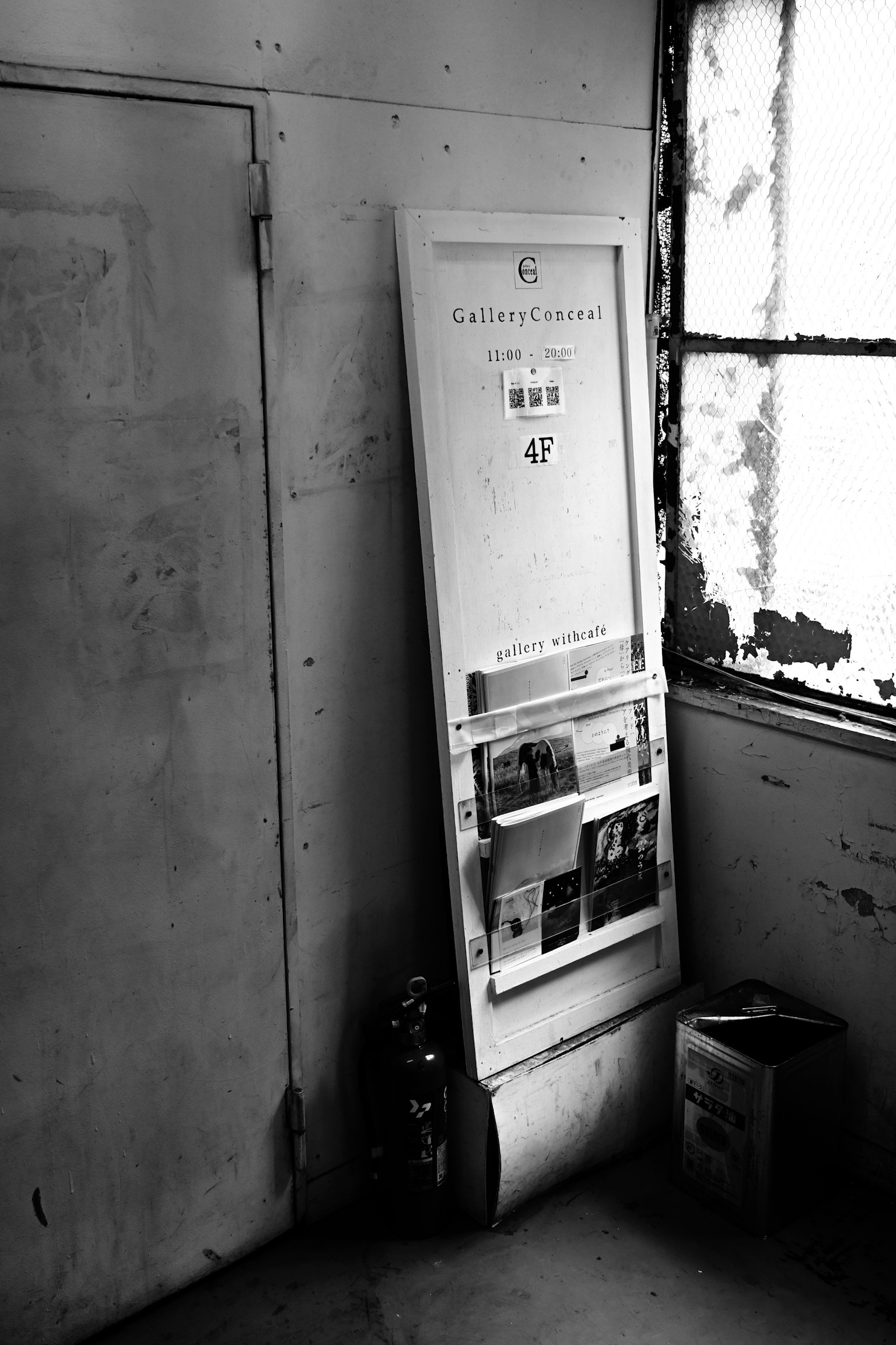 Puerta blanca apoyada contra la pared en una habitación antigua con luz solar entrando por la ventana