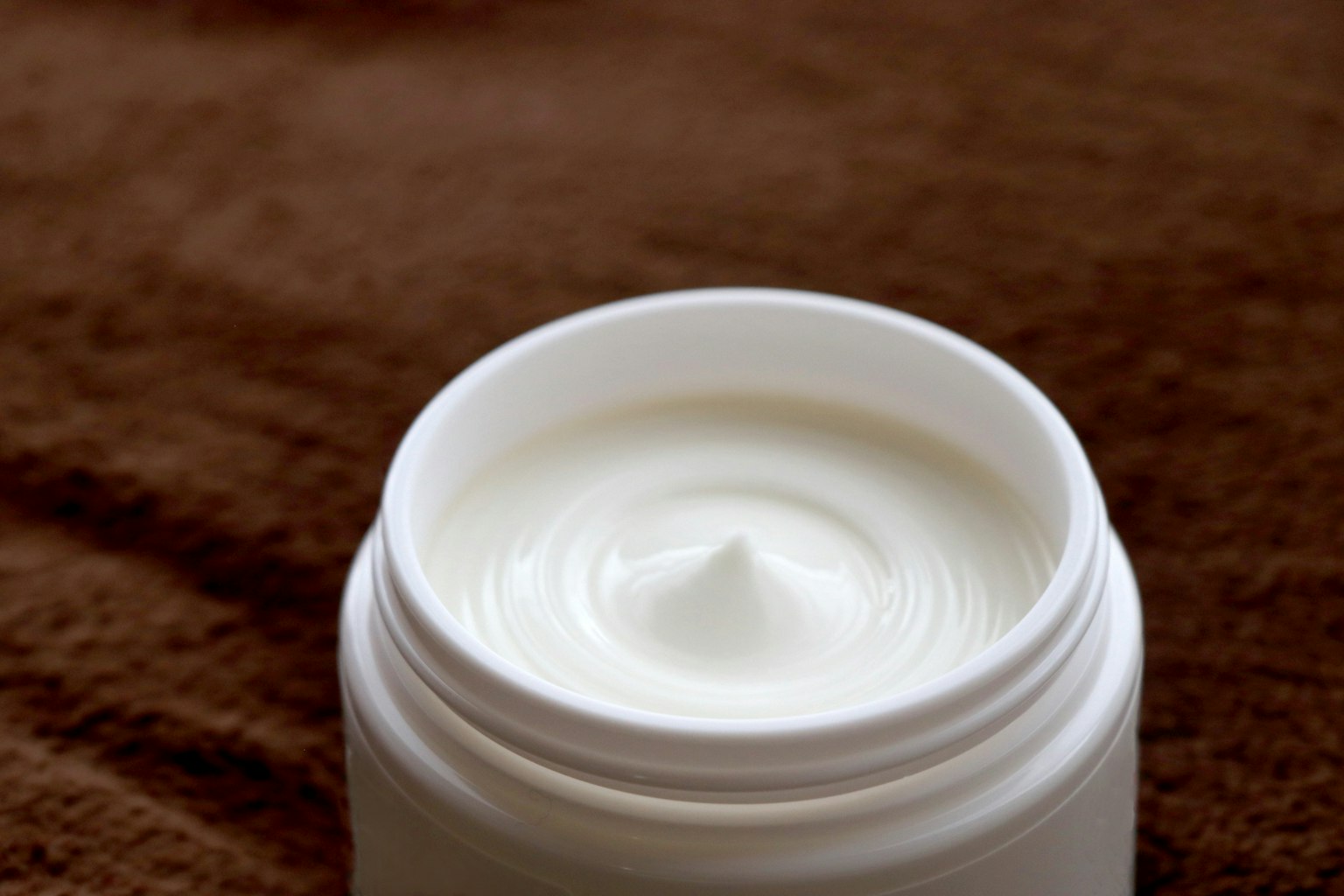 Gros plan d'une crème blanche à l'intérieur d'un contenant cosmétique
