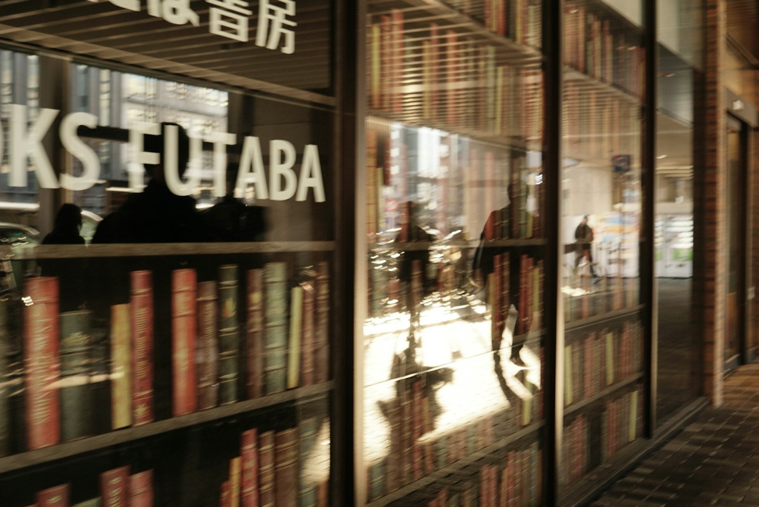 ภายนอกของร้านหนังสือฟุตาบะพร้อมการสะท้อนและชั้นวางหนังสือ