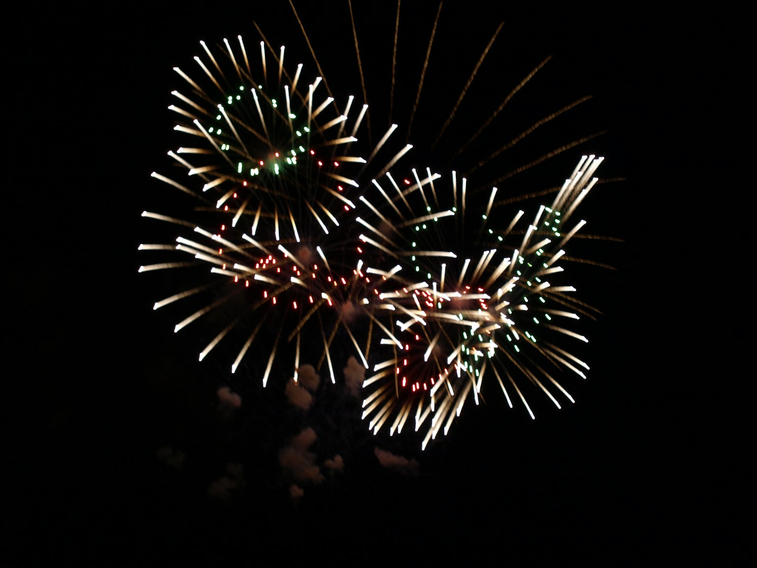 Feuerwerk mit grünen und weißen Mustern auf schwarzem Hintergrund