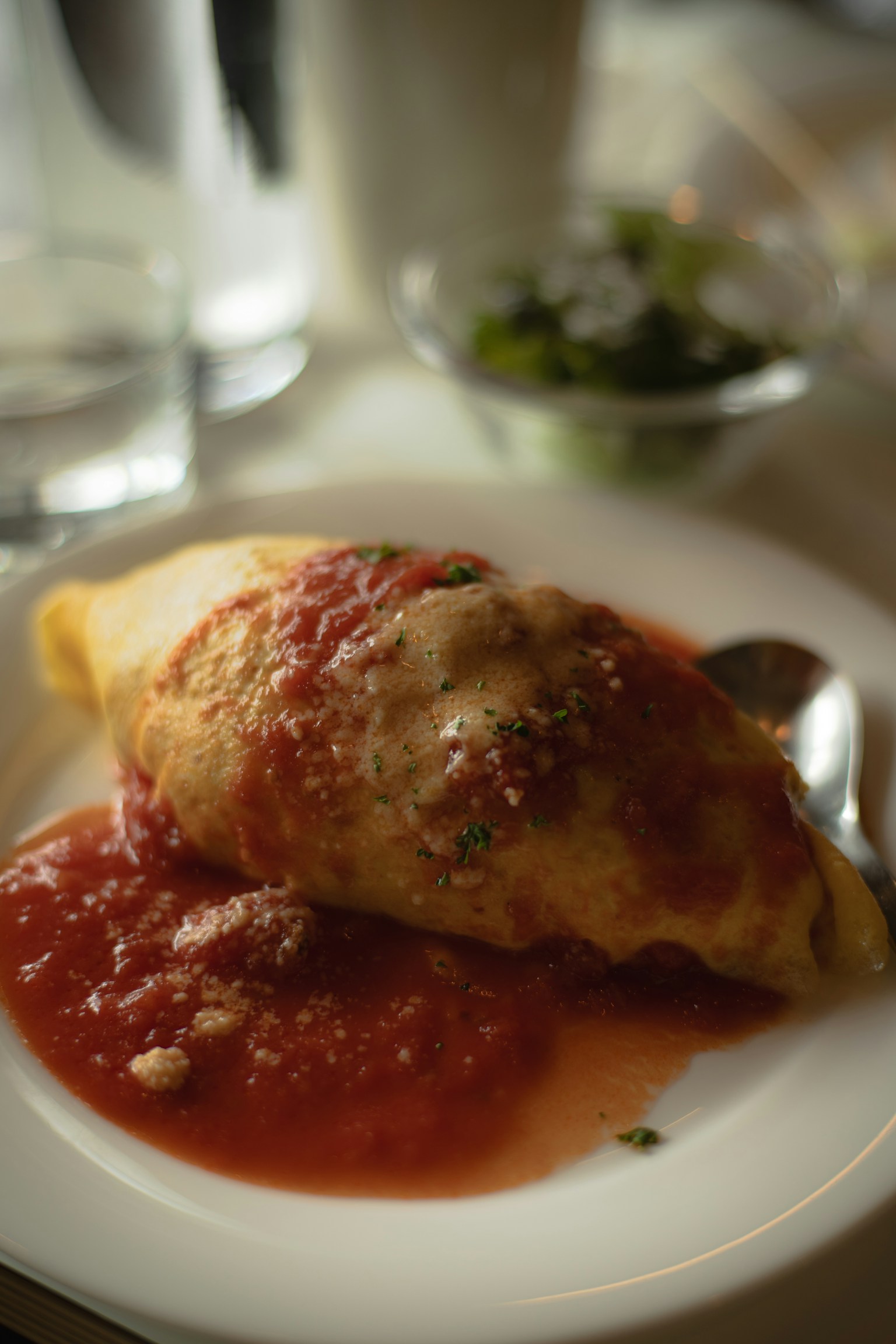 Teller mit Omelette, überzogen mit Tomatensoße und Beilagensalat