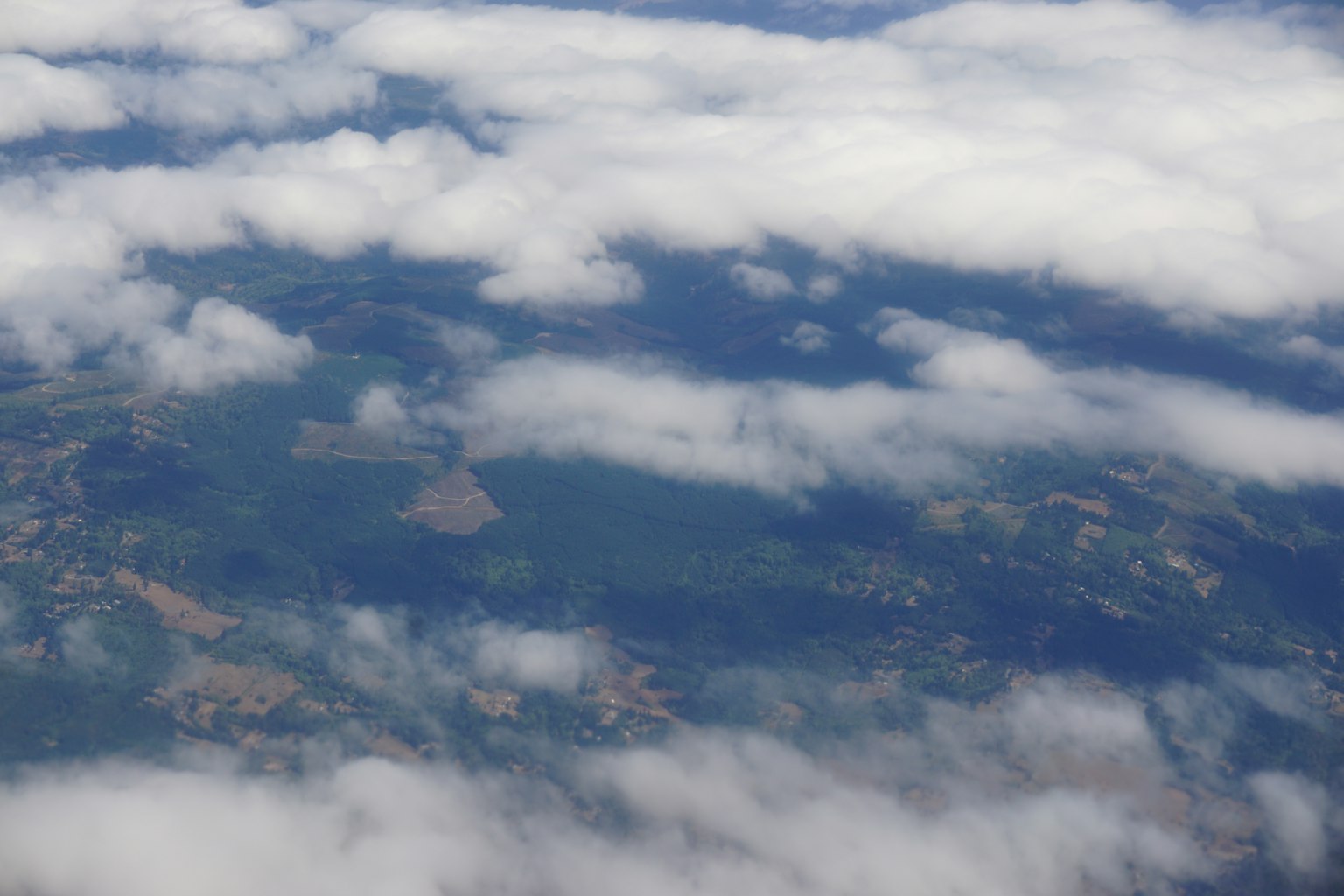 Vista aérea de tierras verdes y nubes blancas