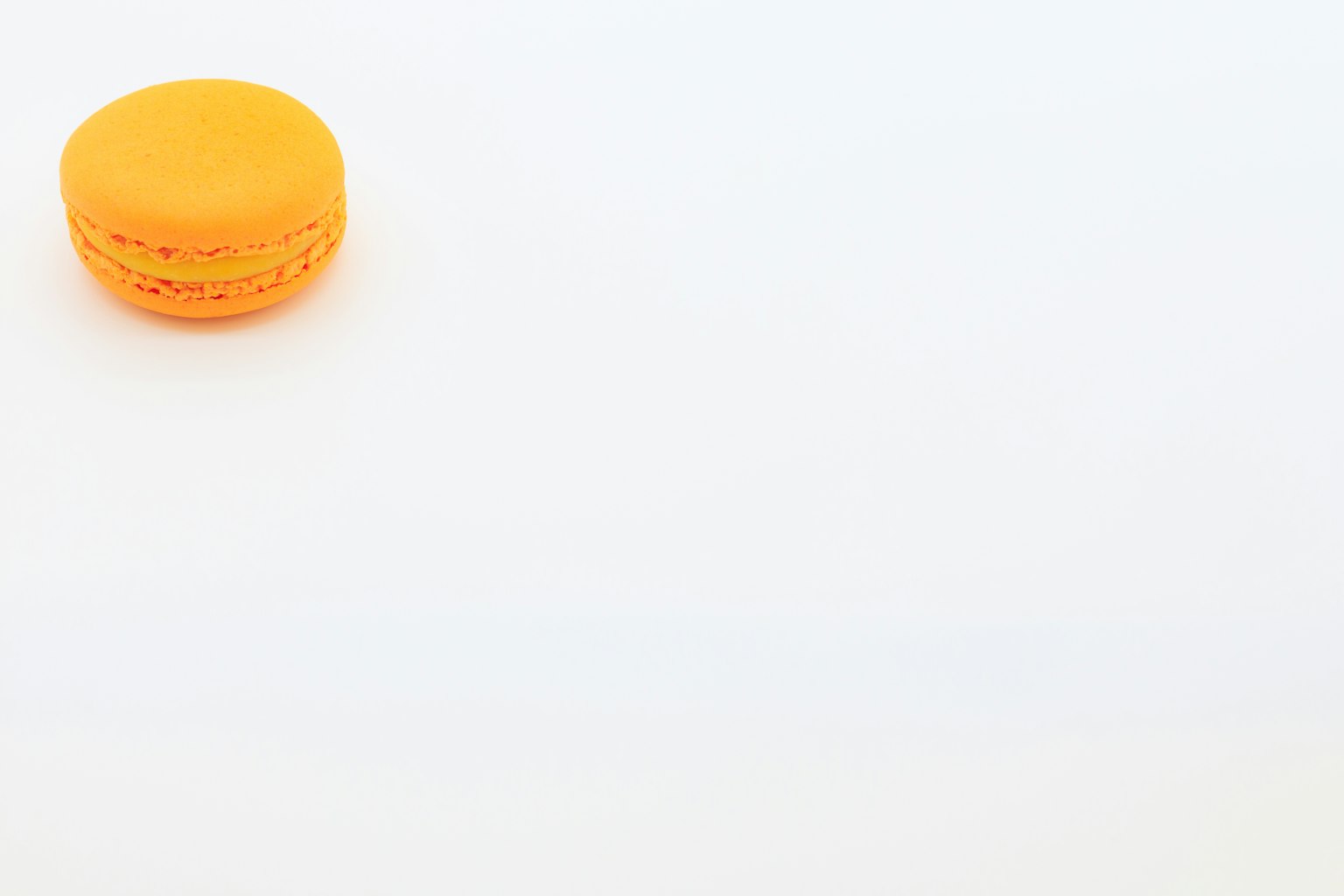 An orange macaron on a white background