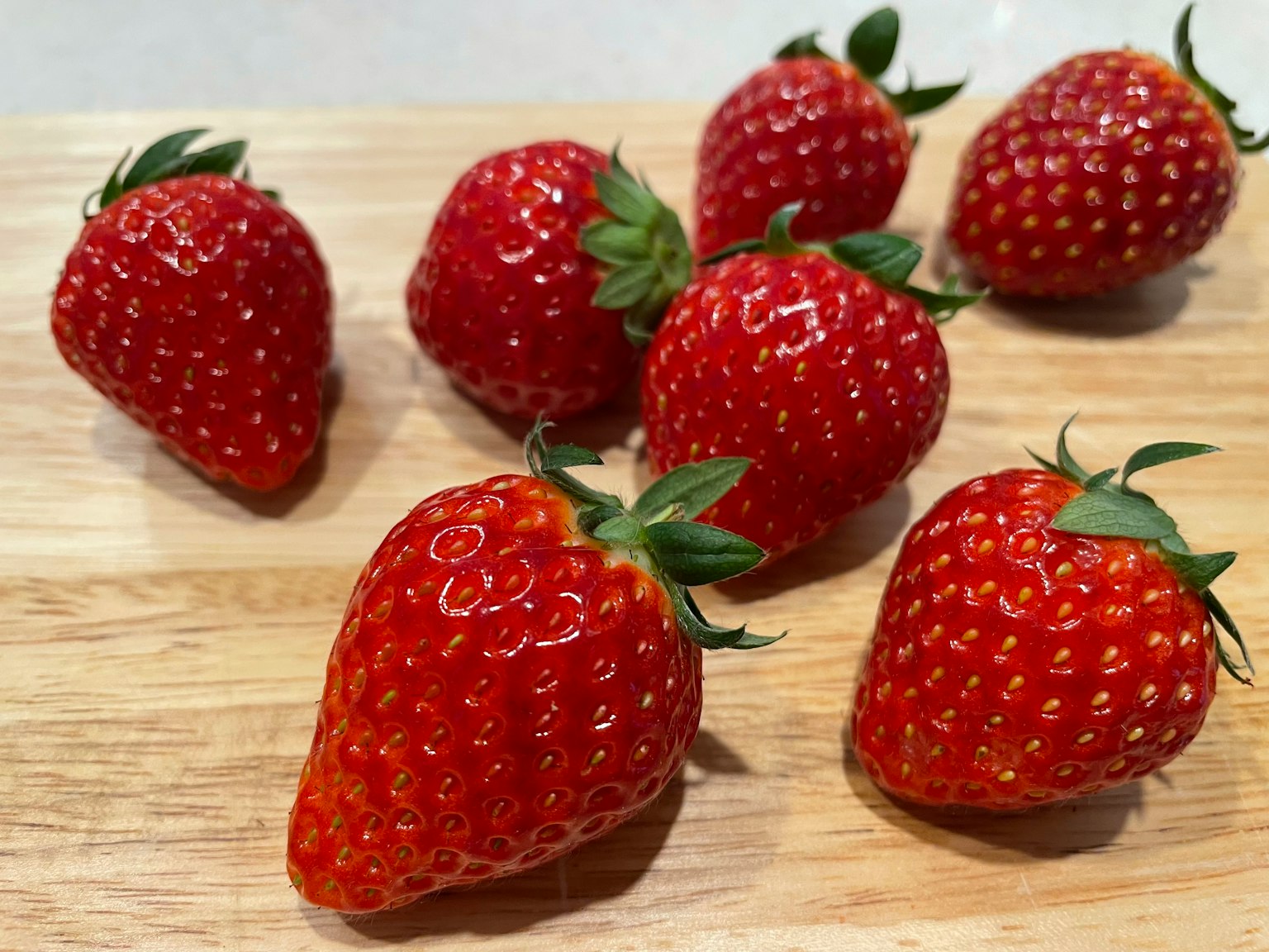 Fraises fraîches disposées sur une planche en bois