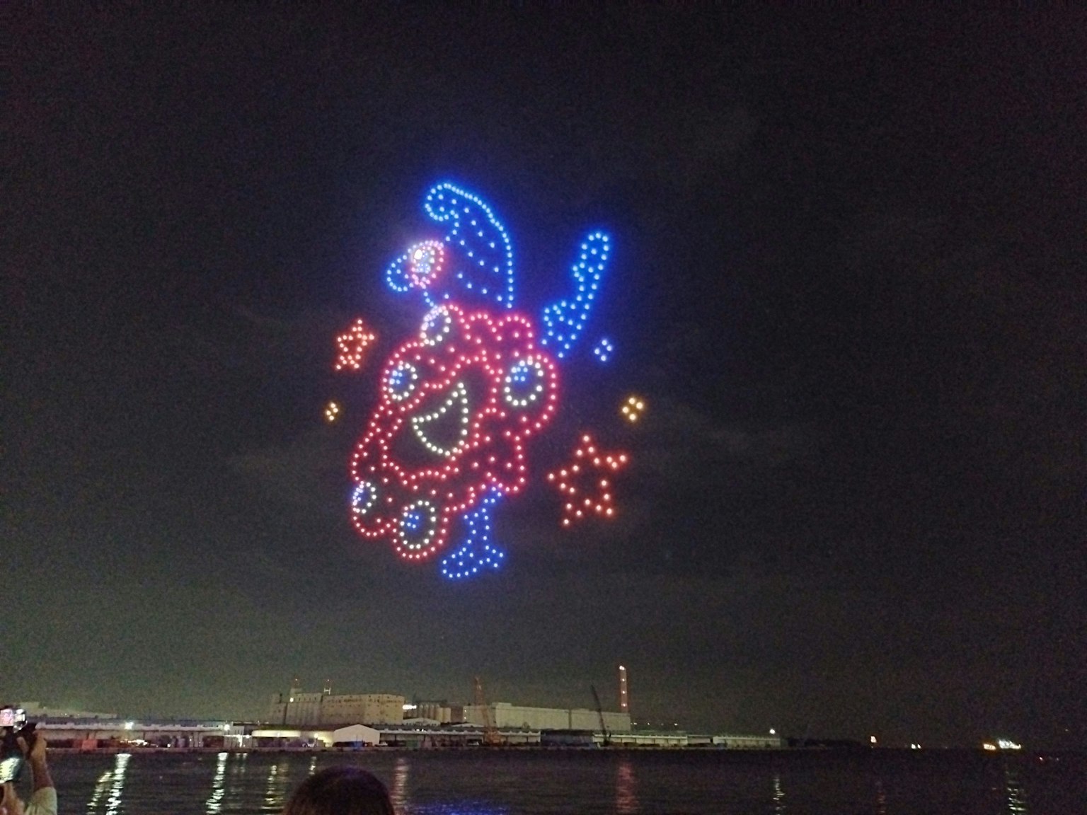 夜空に浮かぶカラフルな花火のデザインで、笑顔の顔と星が描かれている