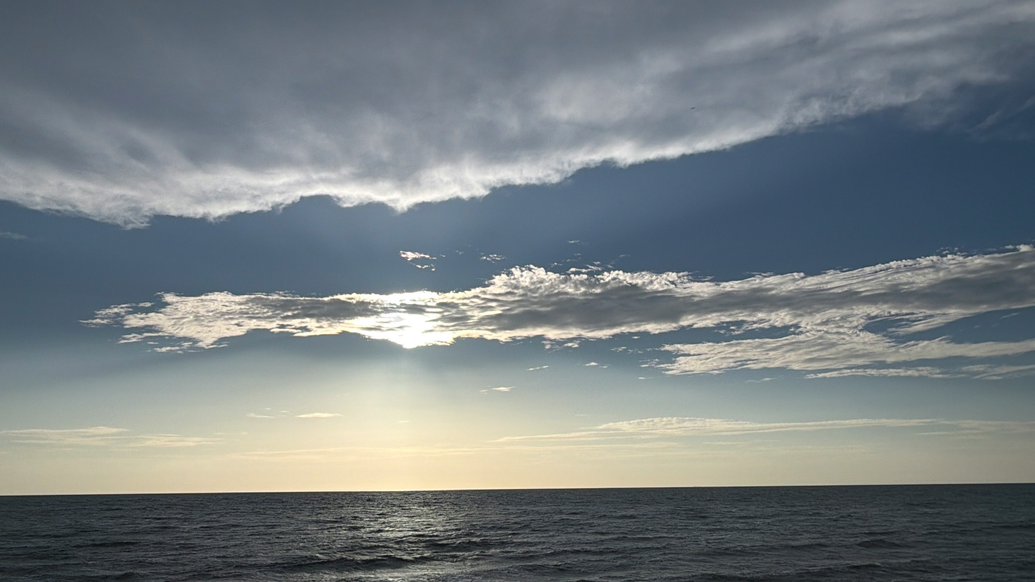 水平線に広がる海と雲の夕景