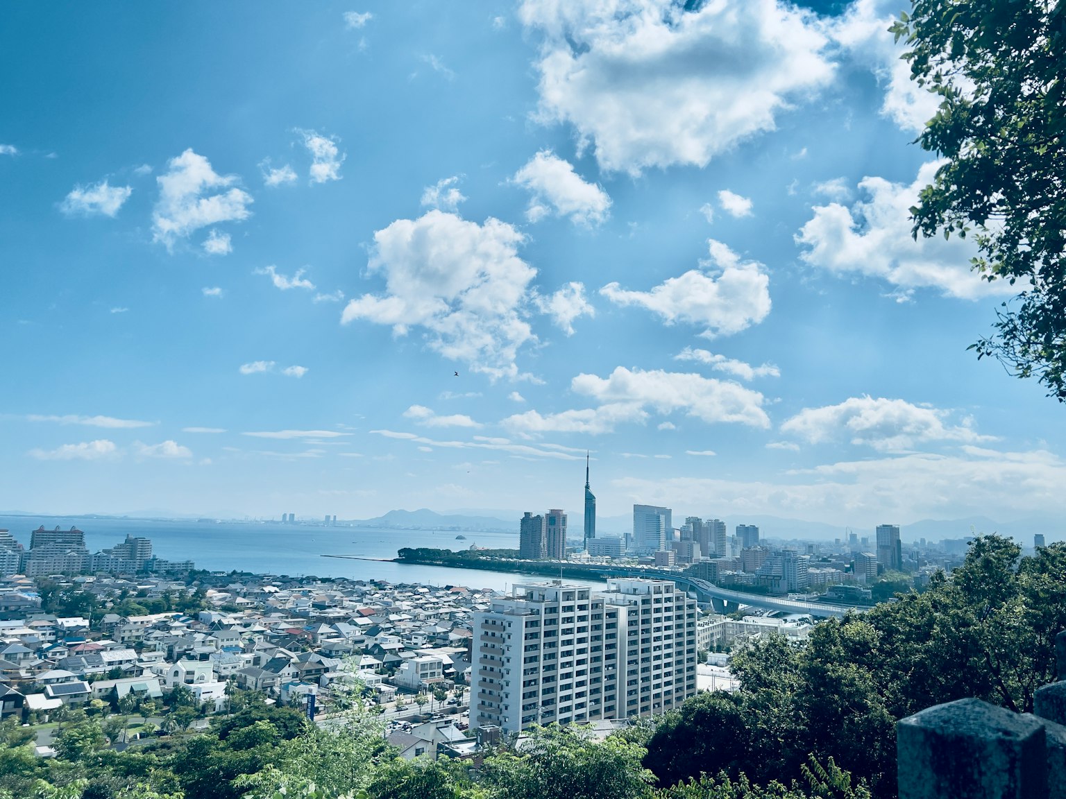 Vista della città con cielo blu e nuvole che sovrastano il mare