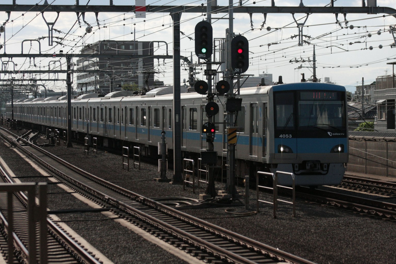 Un treno blu che passa davanti a un segnale in una stazione ferroviaria
