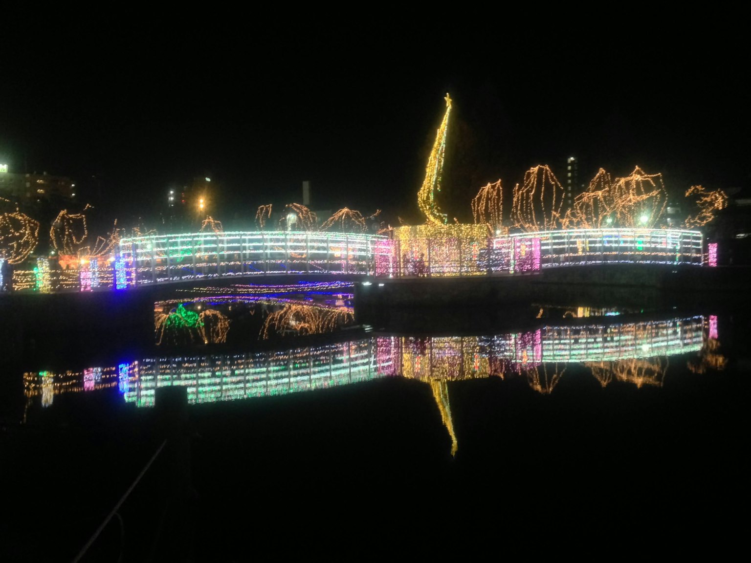 Bunte Lichter spiegeln sich nachts im Fluss