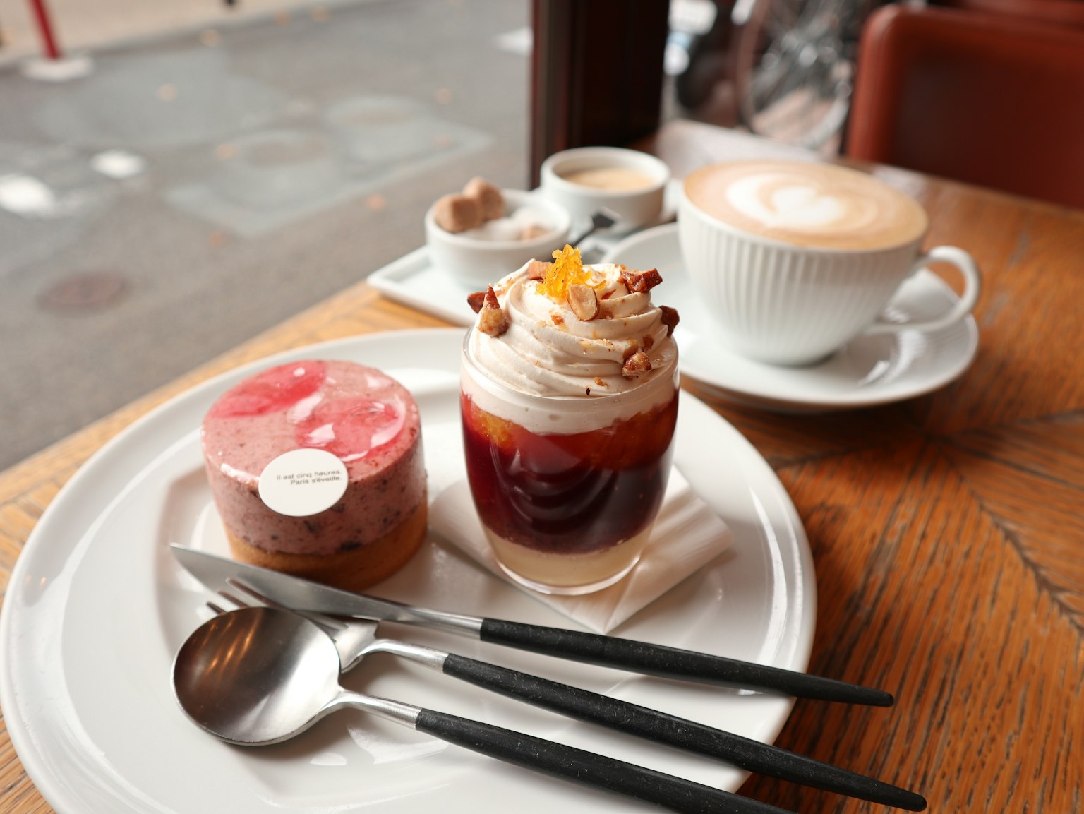 桌上有咖啡和甜點,包括慕斯和分層蛋糕