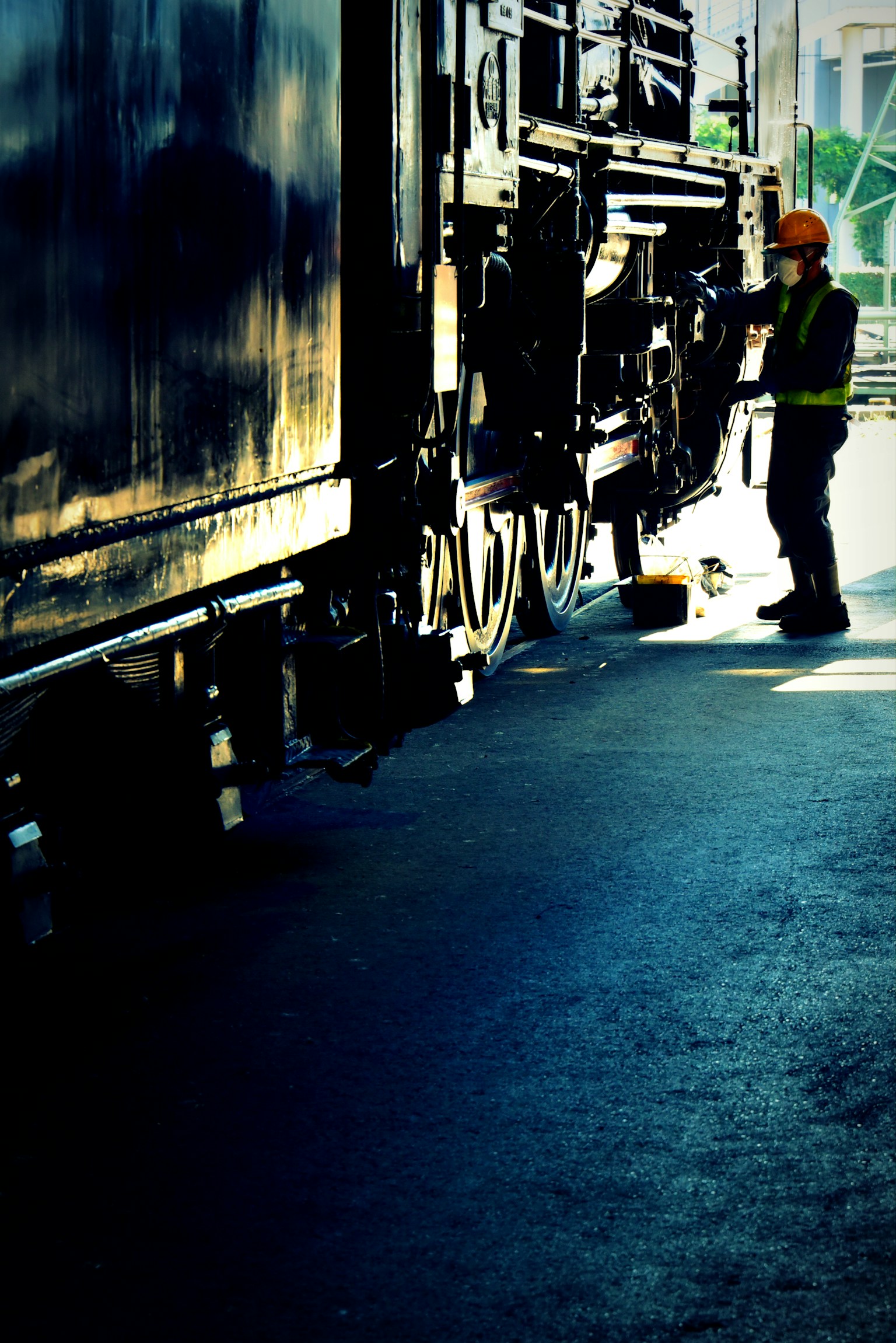 Seorang pekerja dengan perlengkapan keselamatan bekerja di samping truk