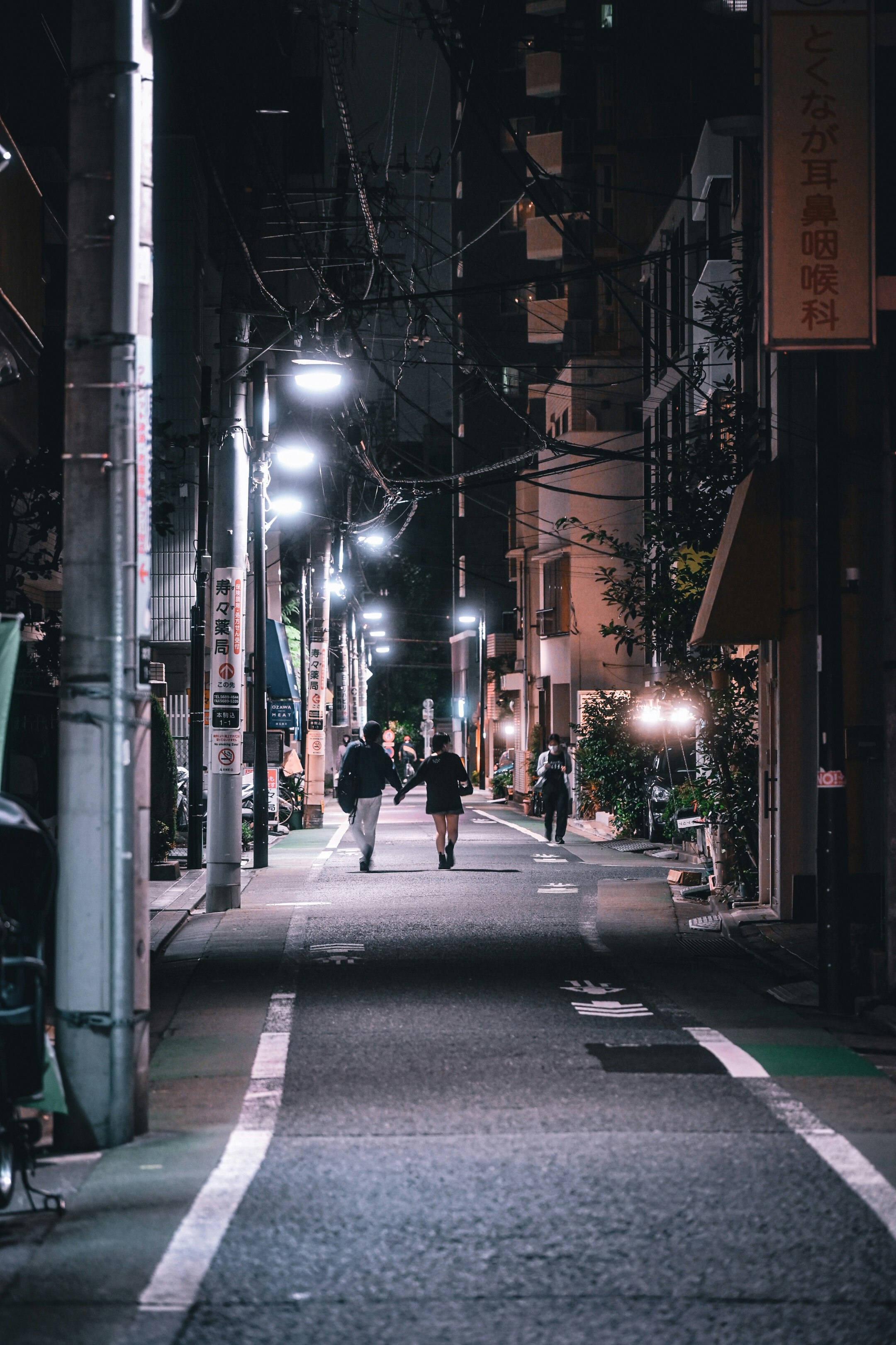 night alley street with pedestrians and streetlights