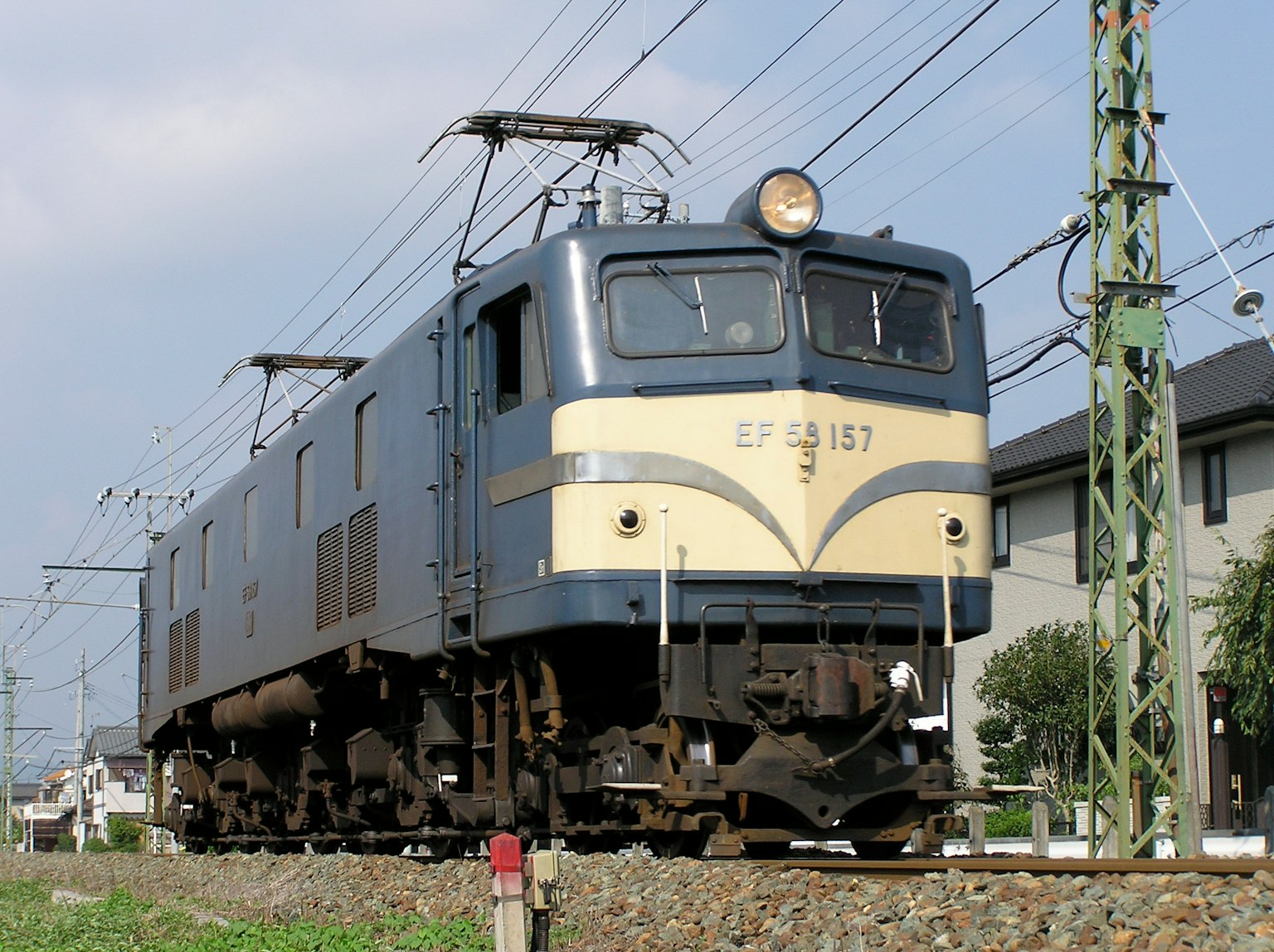Vista lateral de una locomotora eléctrica azul en las vías