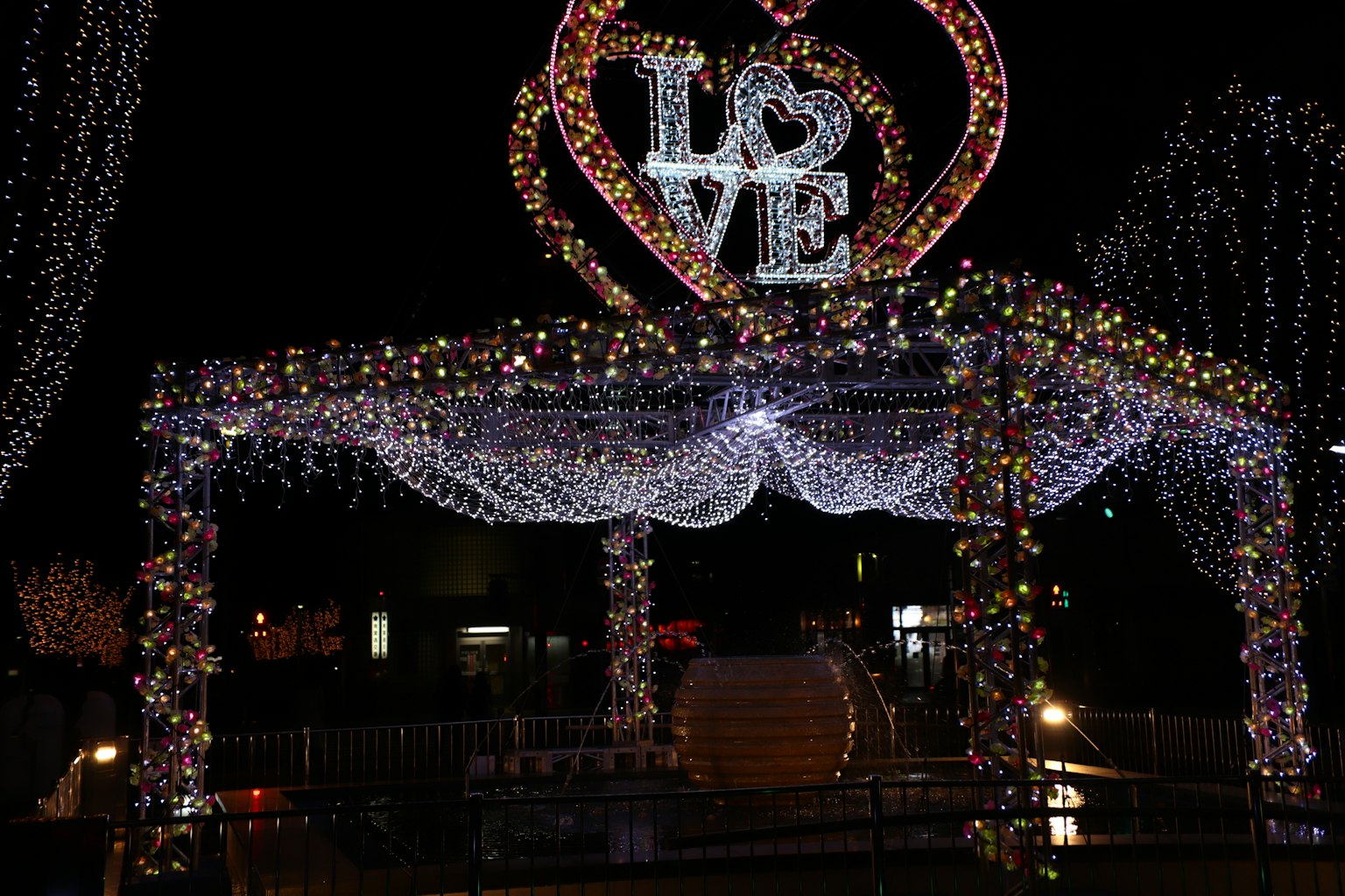 Un arco illuminato con la parola amore circondato da luci scintillanti