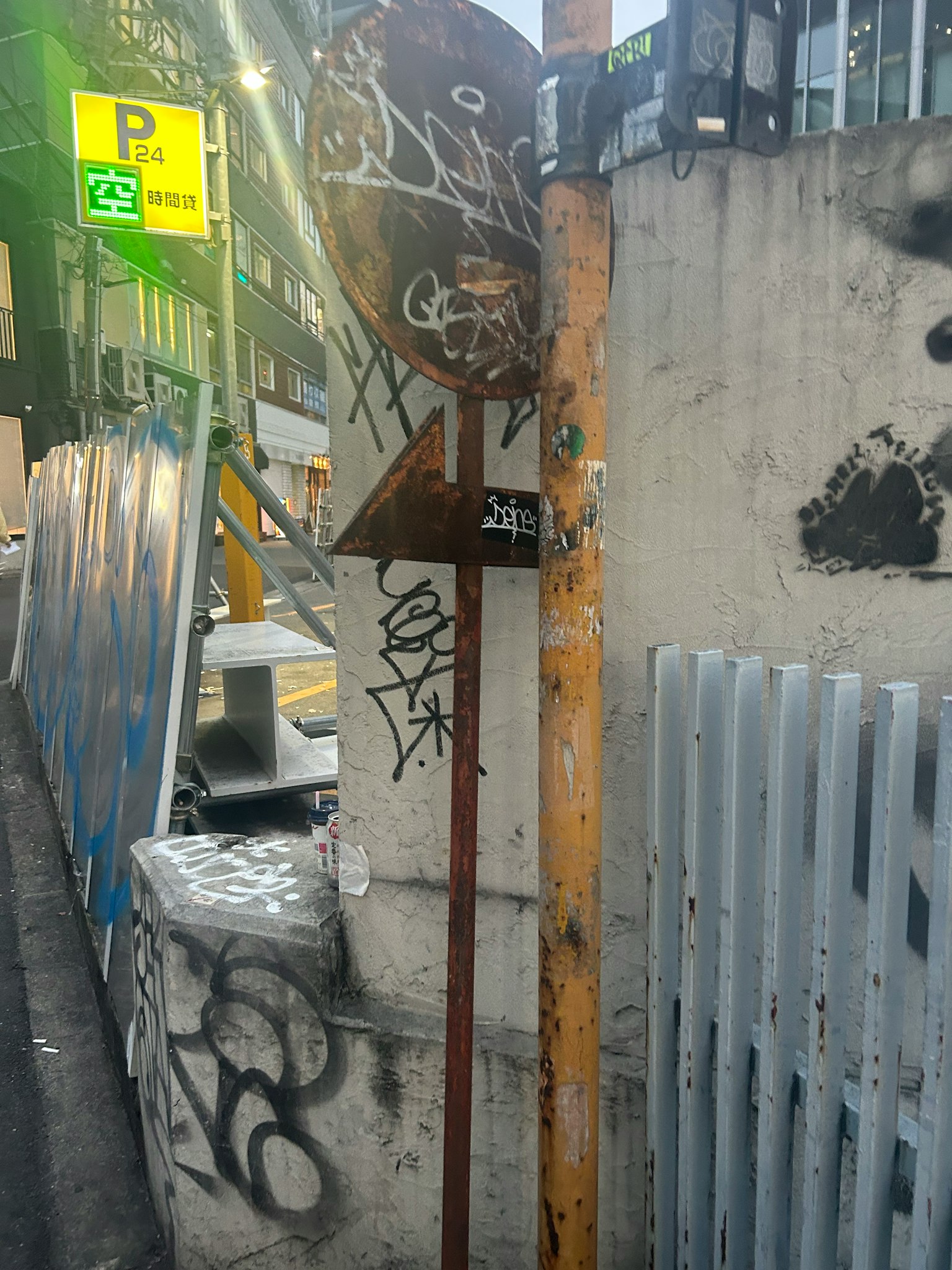 Straßenschild mit Graffiti und Betonwand