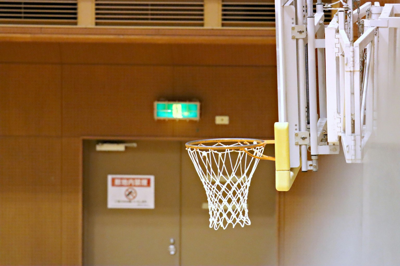 Interno di una palestra con un canestro da basket e un muro