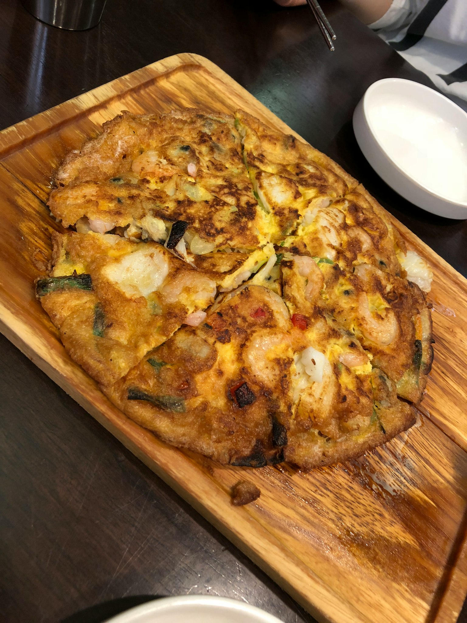 Galette de fruits de mer coréenne servie sur une planche en bois
