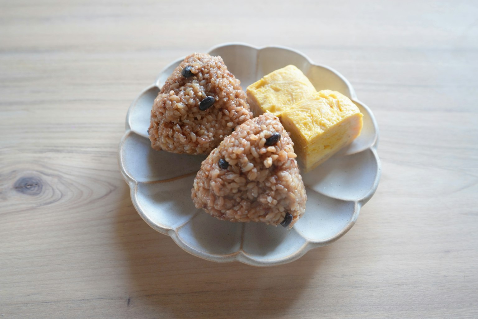 Gambar bola nasi dan omelet di piring putih