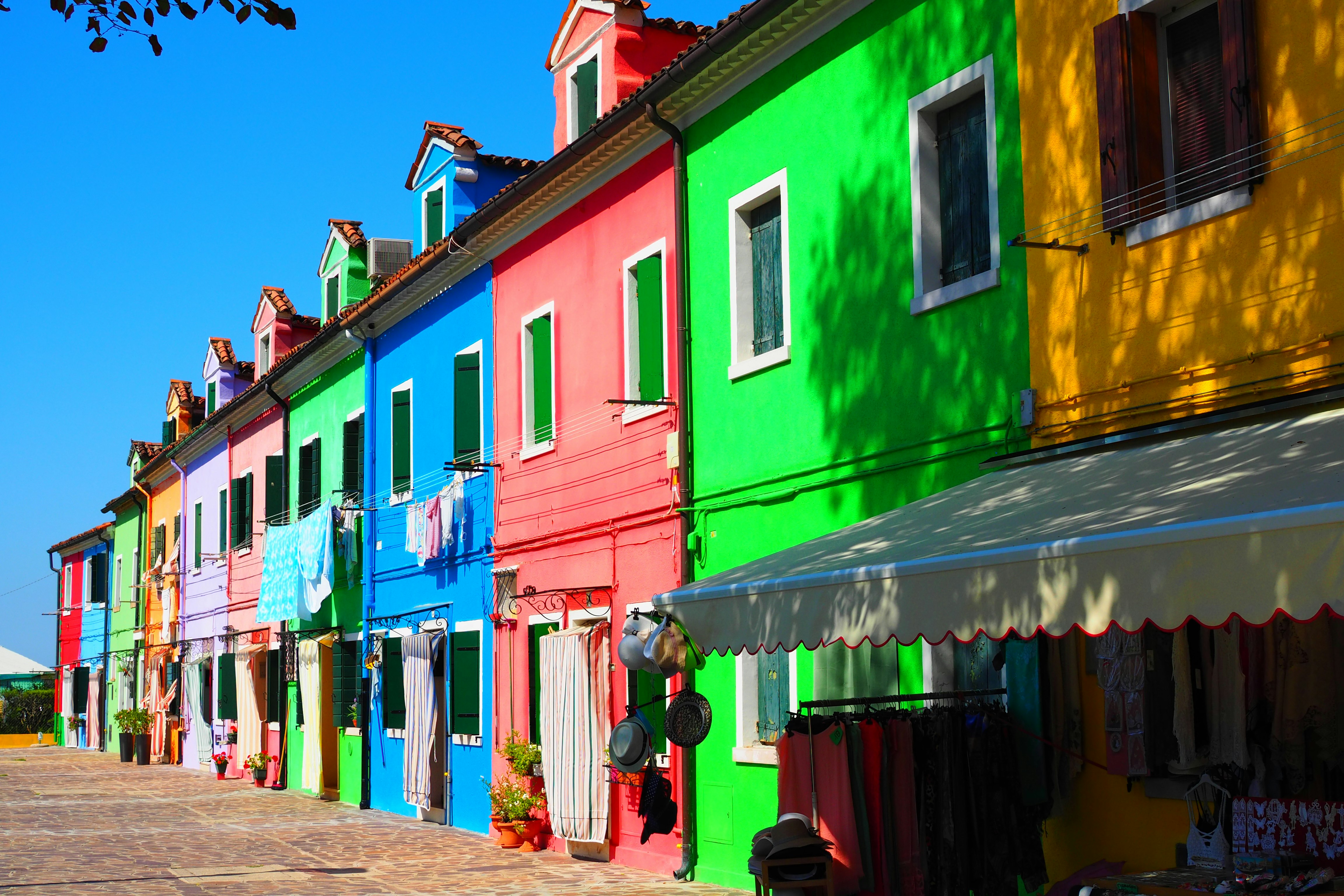 Hilera de casas coloridas con toldos de tiendas a lo largo de una calle