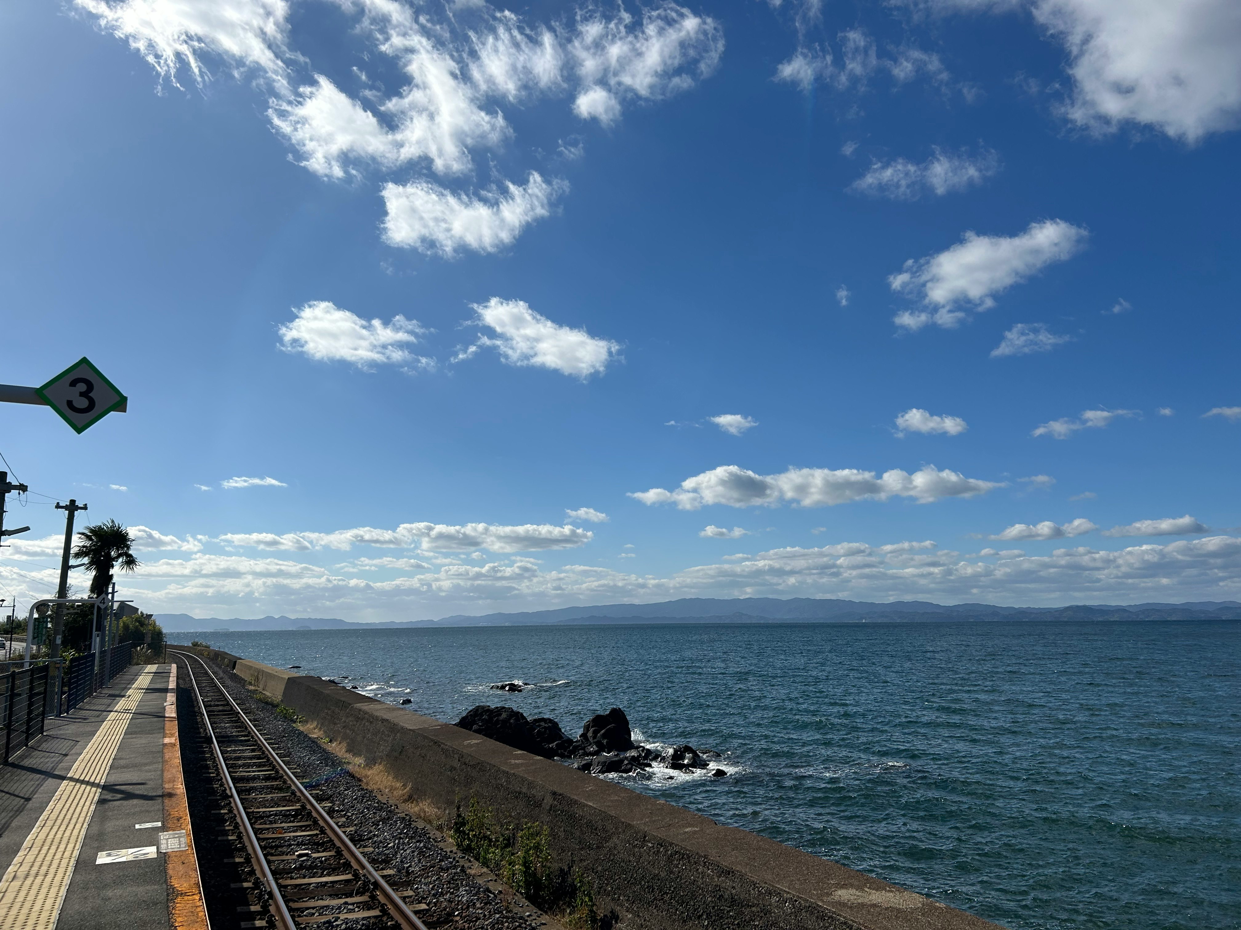 冬の海沿いの線路と青い空の風景
