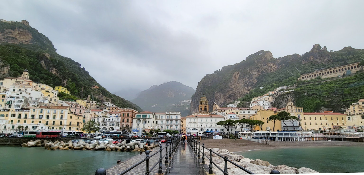 Amalfi Coast harbor with mountains cloudy sky and calm sea