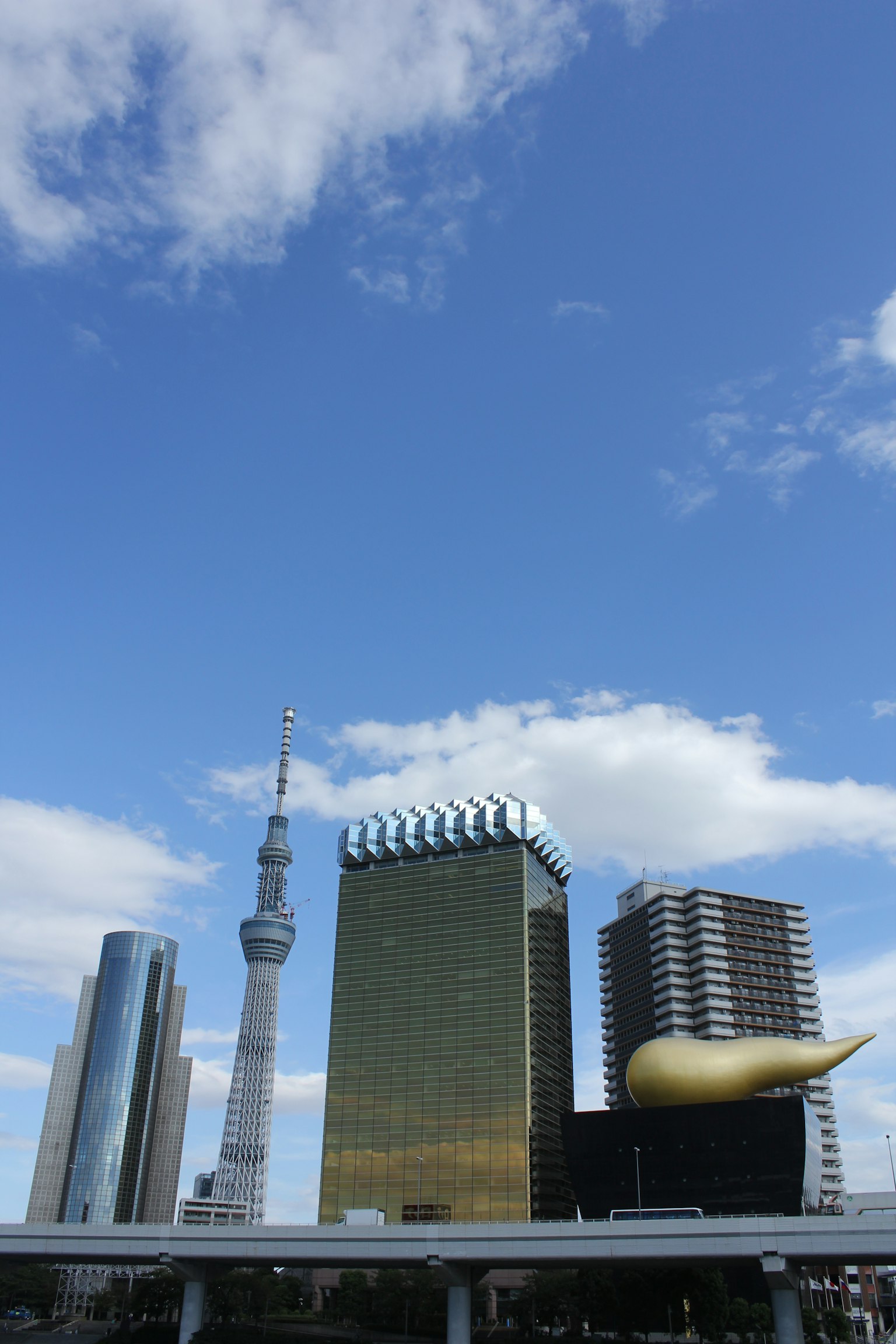Vista della Tokyo Skytree e della Torre Asahi sotto un cielo blu