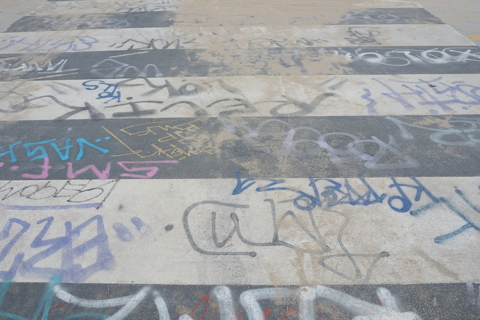 Image of a ground with black and white stripes covered in graffiti