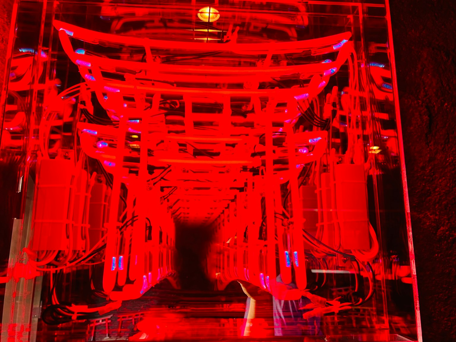 โครงสร้างอุโมงค์ที่คล้ายกับประตูโทริอิที่มีแสงสีแดง