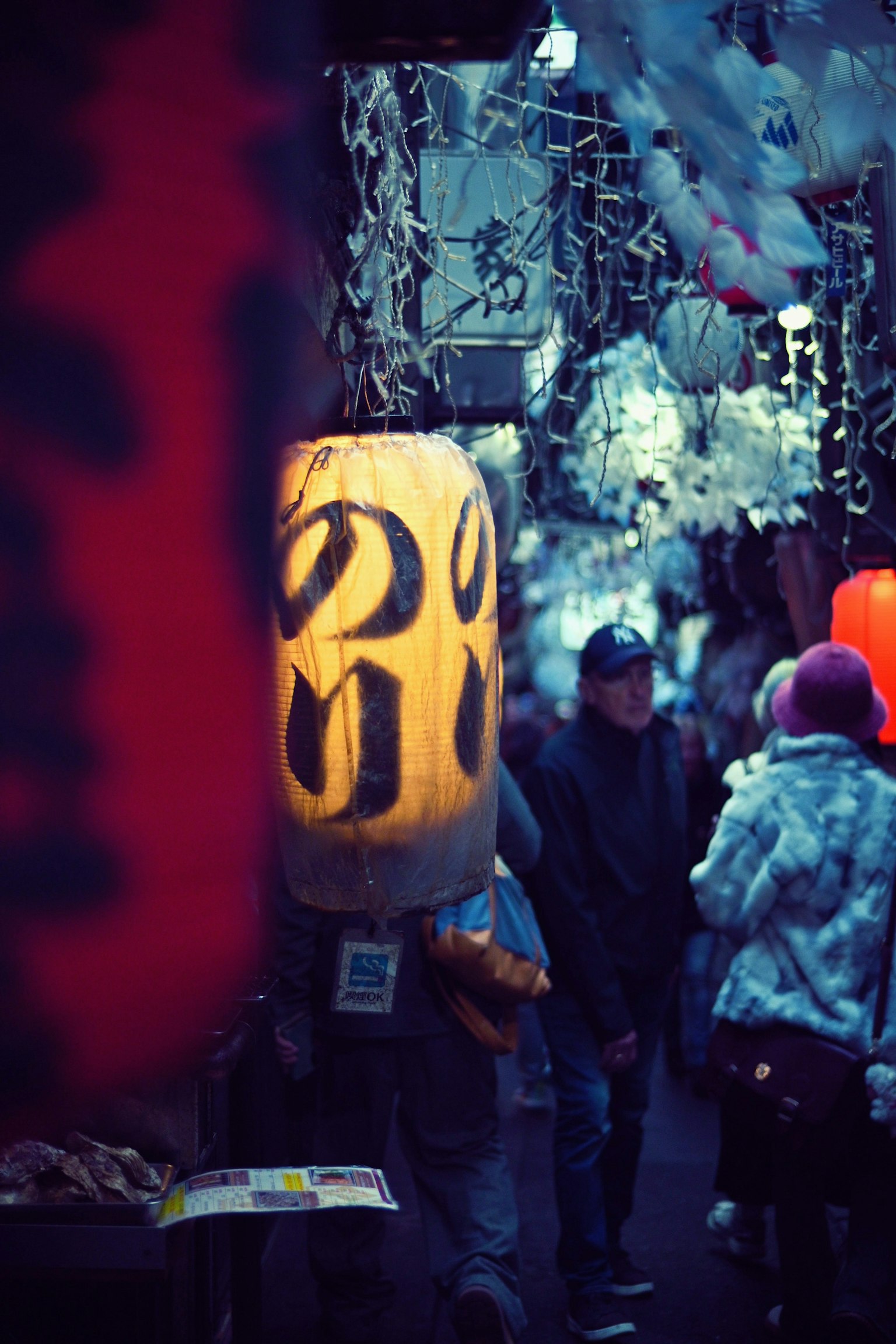 โคมไฟที่สว่างในตลาดกลางคืนพร้อมผู้คนที่เดิน