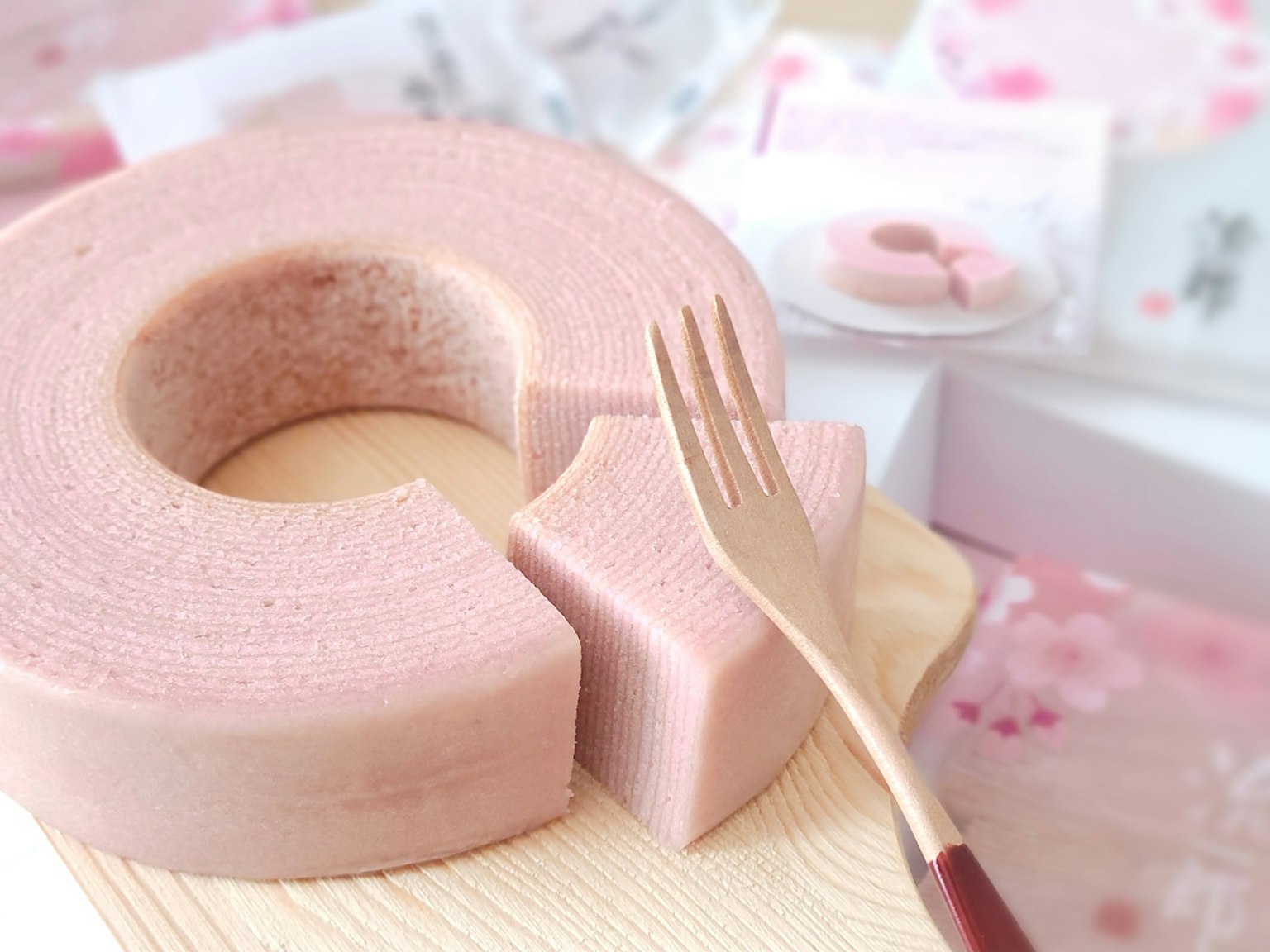 Baumkuchen rosa en un plato de madera con un tenedor insertado