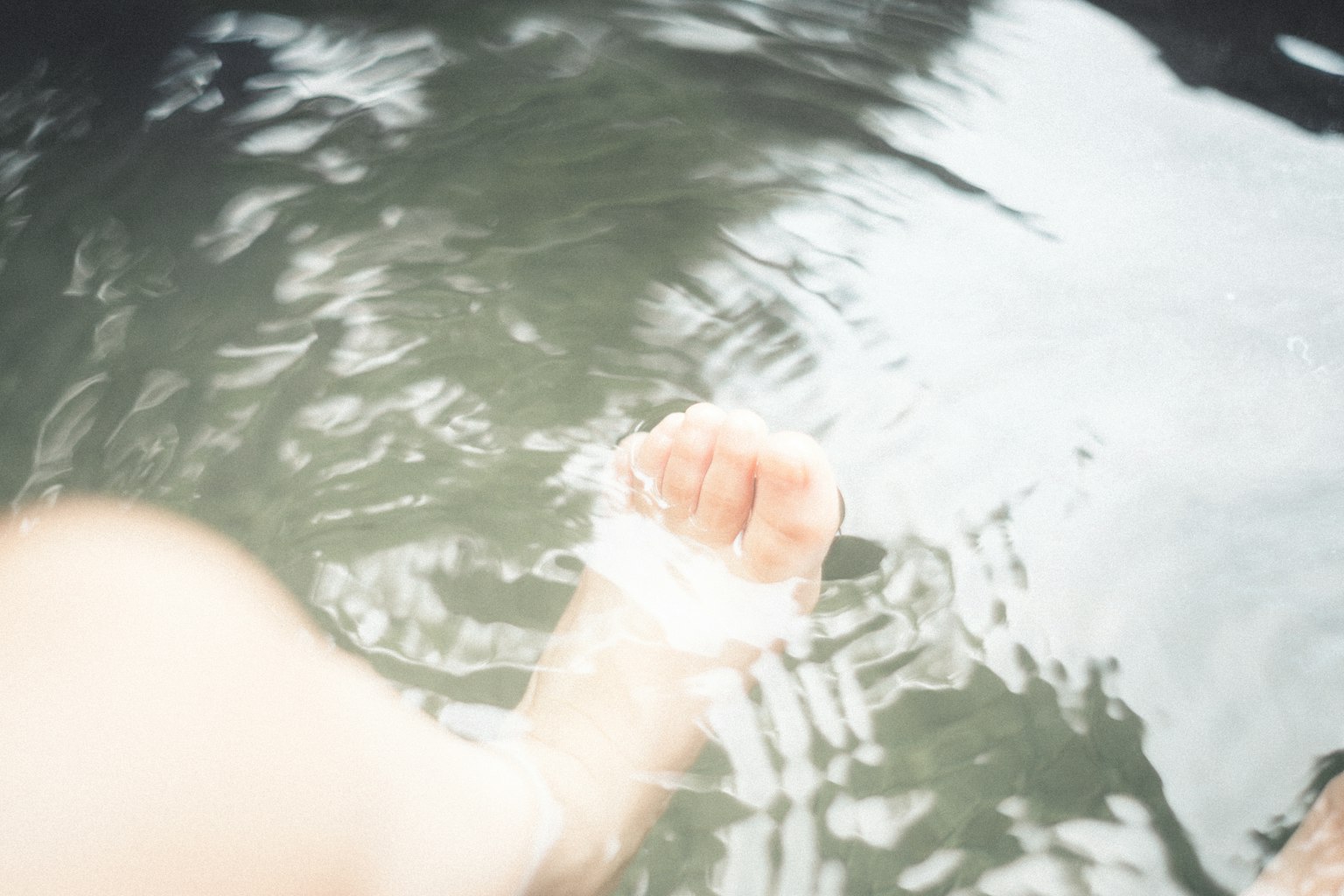 Eine Hand, die ins Wasser taucht und Wellen erzeugt