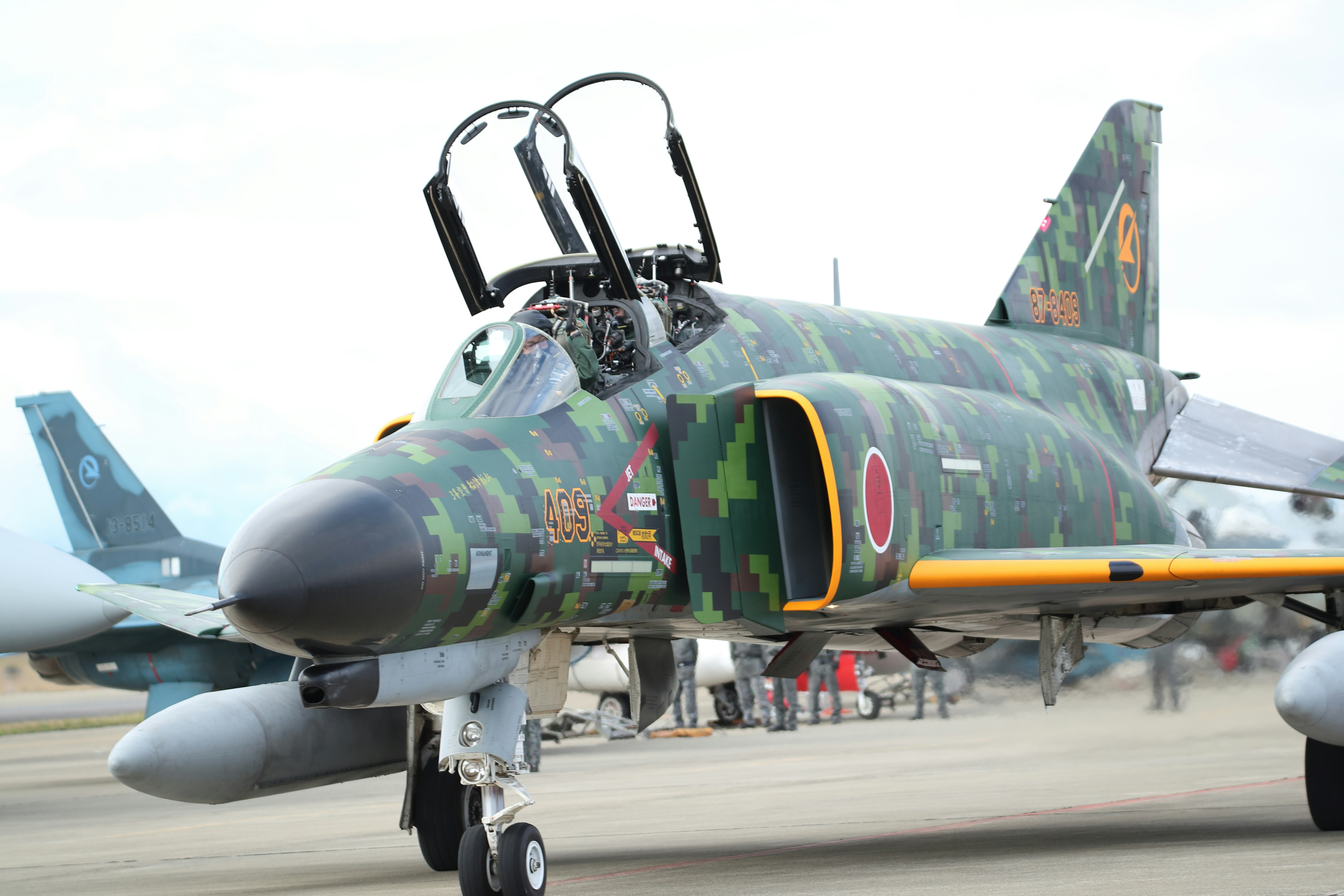 迷彩塗装の戦闘機が並ぶ滑走路の前景