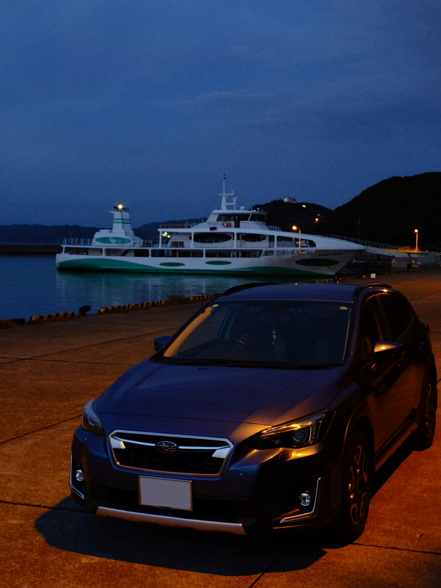 night harbor quay with a sightseeing cruise ship and parked car