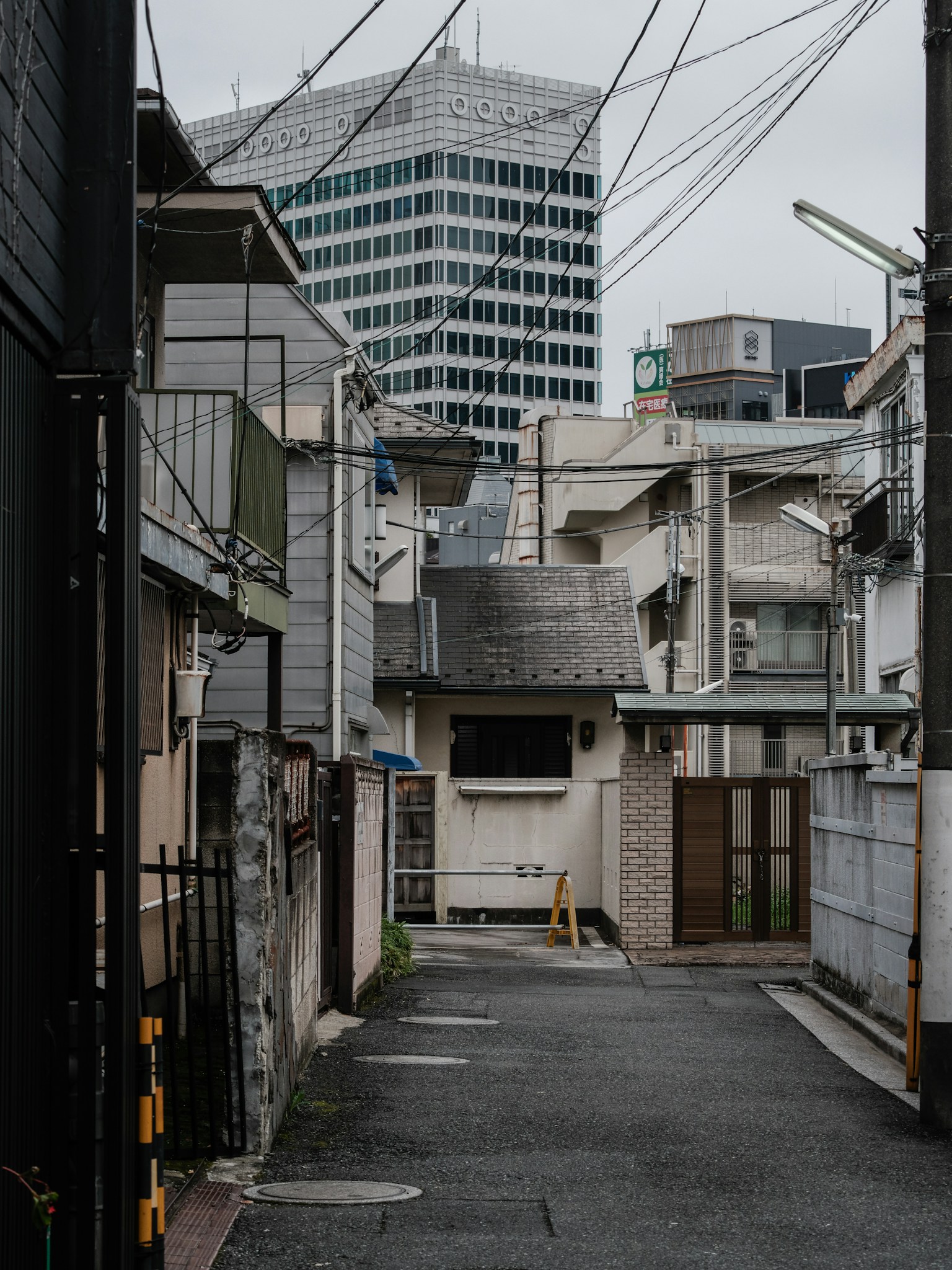 Narrow alley with buildings and a skyscraper in the background