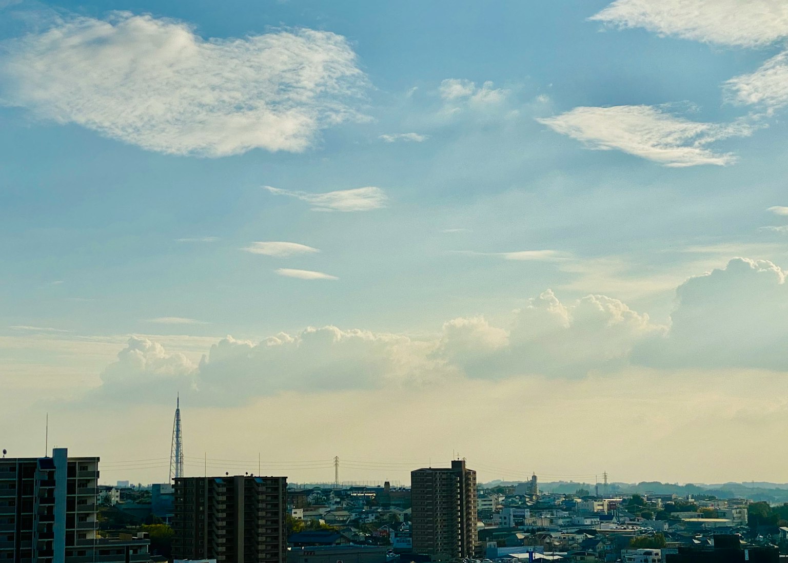 Garis langit perkotaan dengan langit biru dan awan tersebar