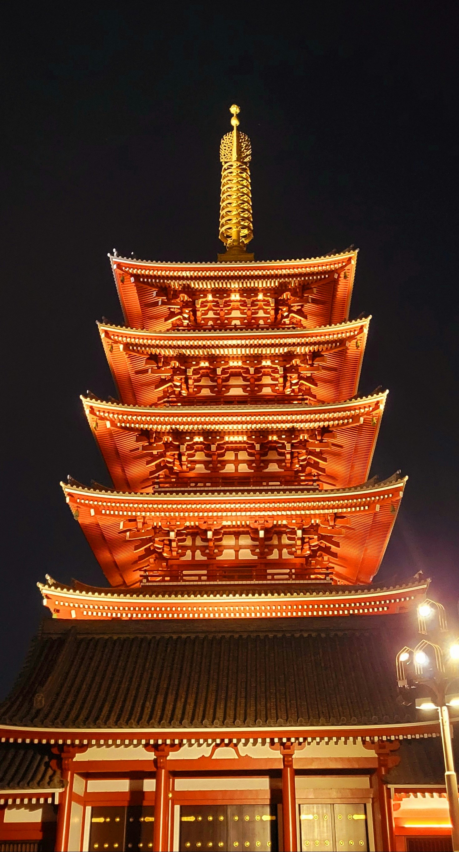 Vue nocturne d’un temple rouge avec des lanternes allumées