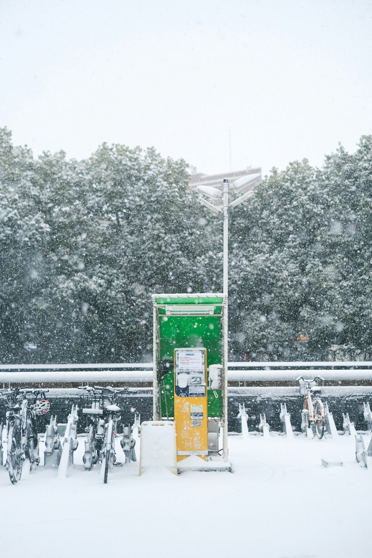 雪の降る東京の駅前の自転車置き場