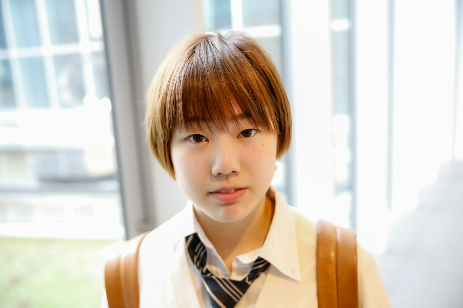 Young woman with distinctive hairstyle wearing a white shirt and tie