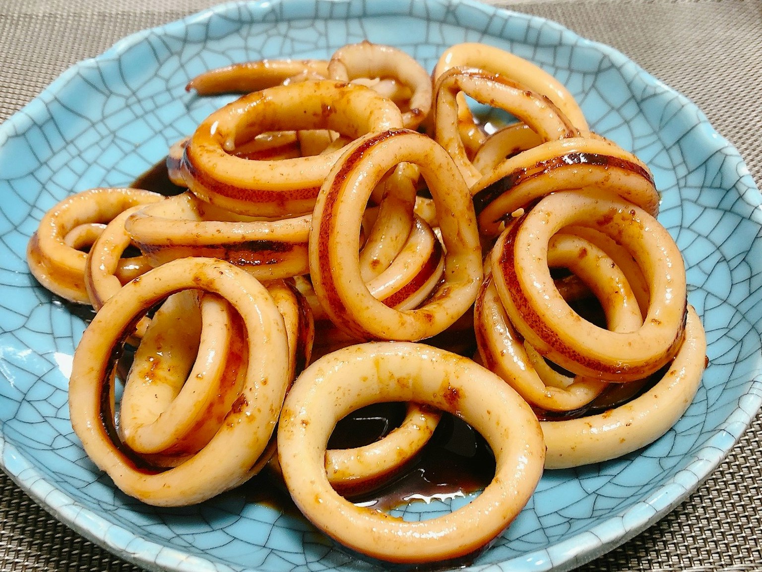 Anelli di calamaro dolci e salati serviti su un piatto blu
