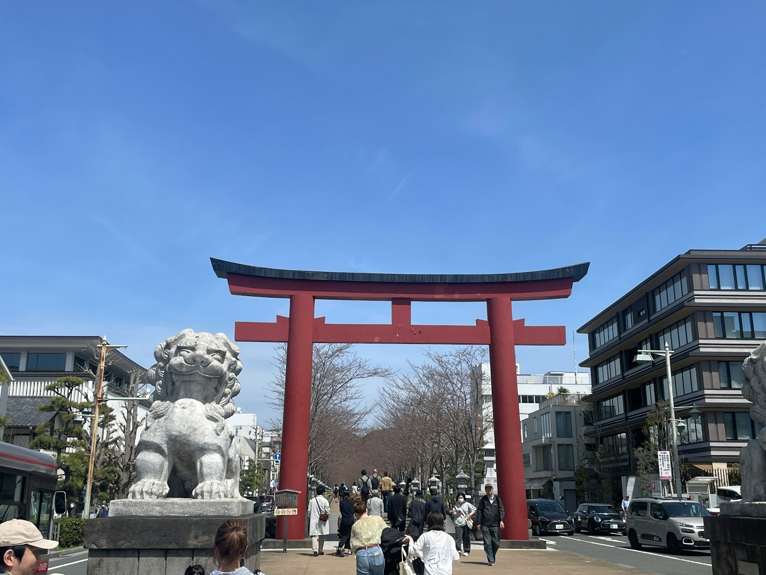 Street scene featuring a red torii gate and guardian lion statues
