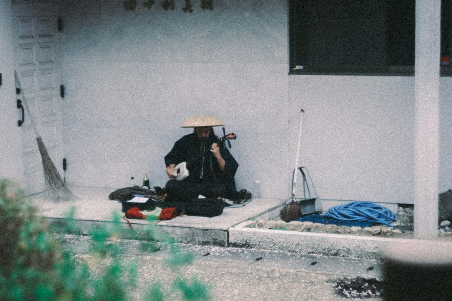 Orang yang memainkan alat musik di luar ruangan dengan bangunan di latar belakang
