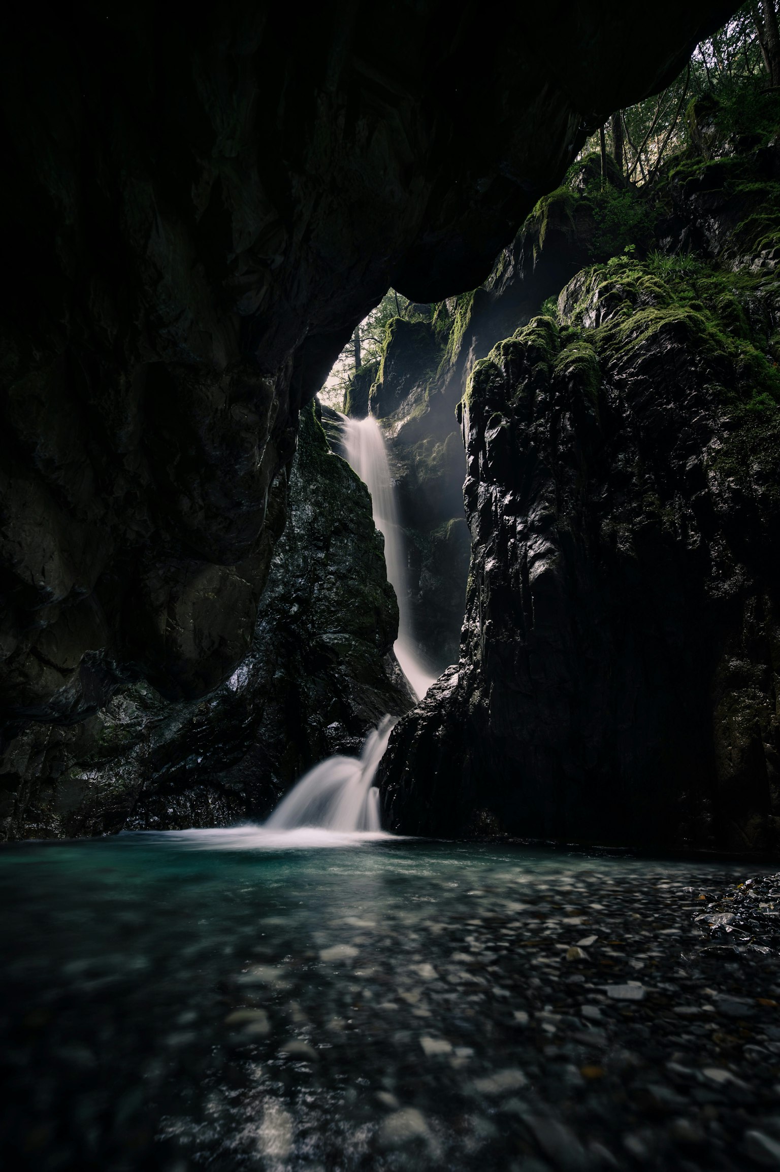 Une cascade tombant dans une grotte sombre avec une surface d'eau sereine